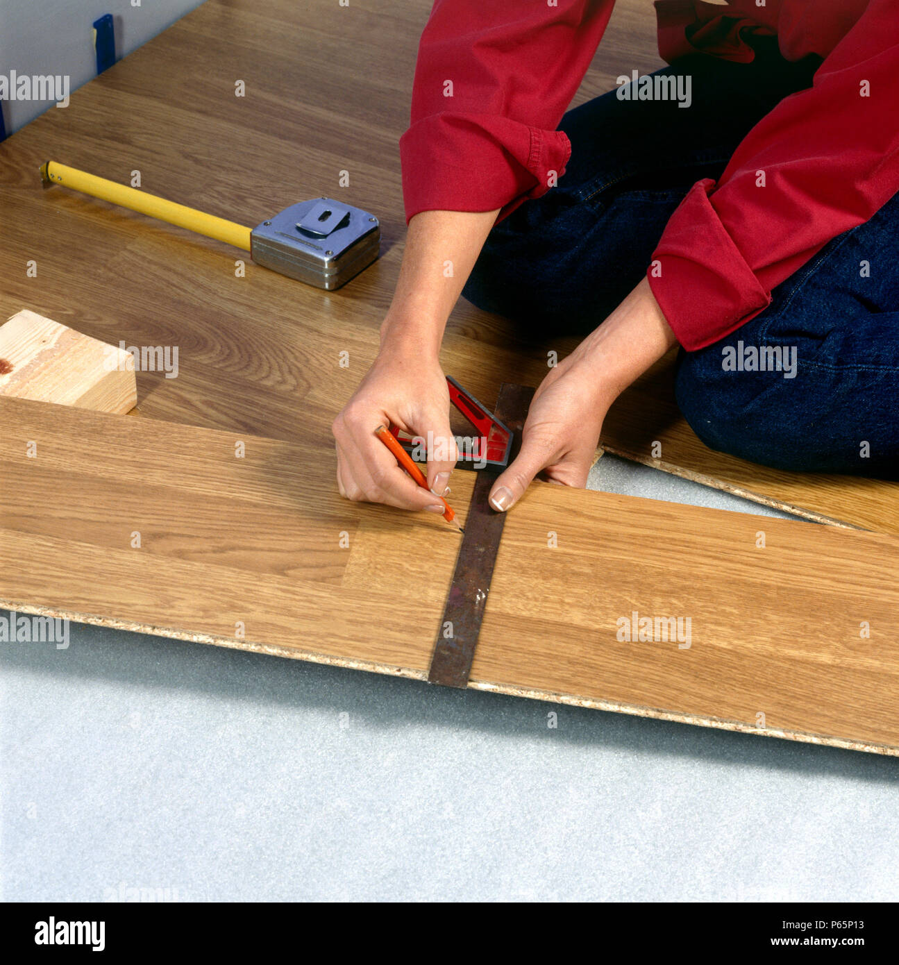 Woman laying new laminated floorboard Stock Photo Alamy