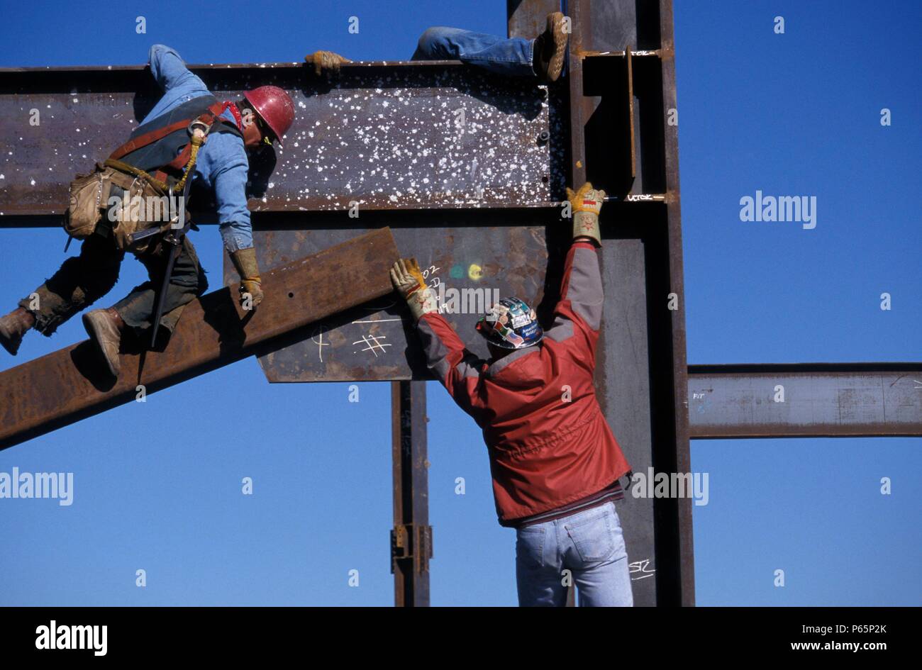 Ironworker connectors installing steel beam on high rise office building framework Stock Photo
