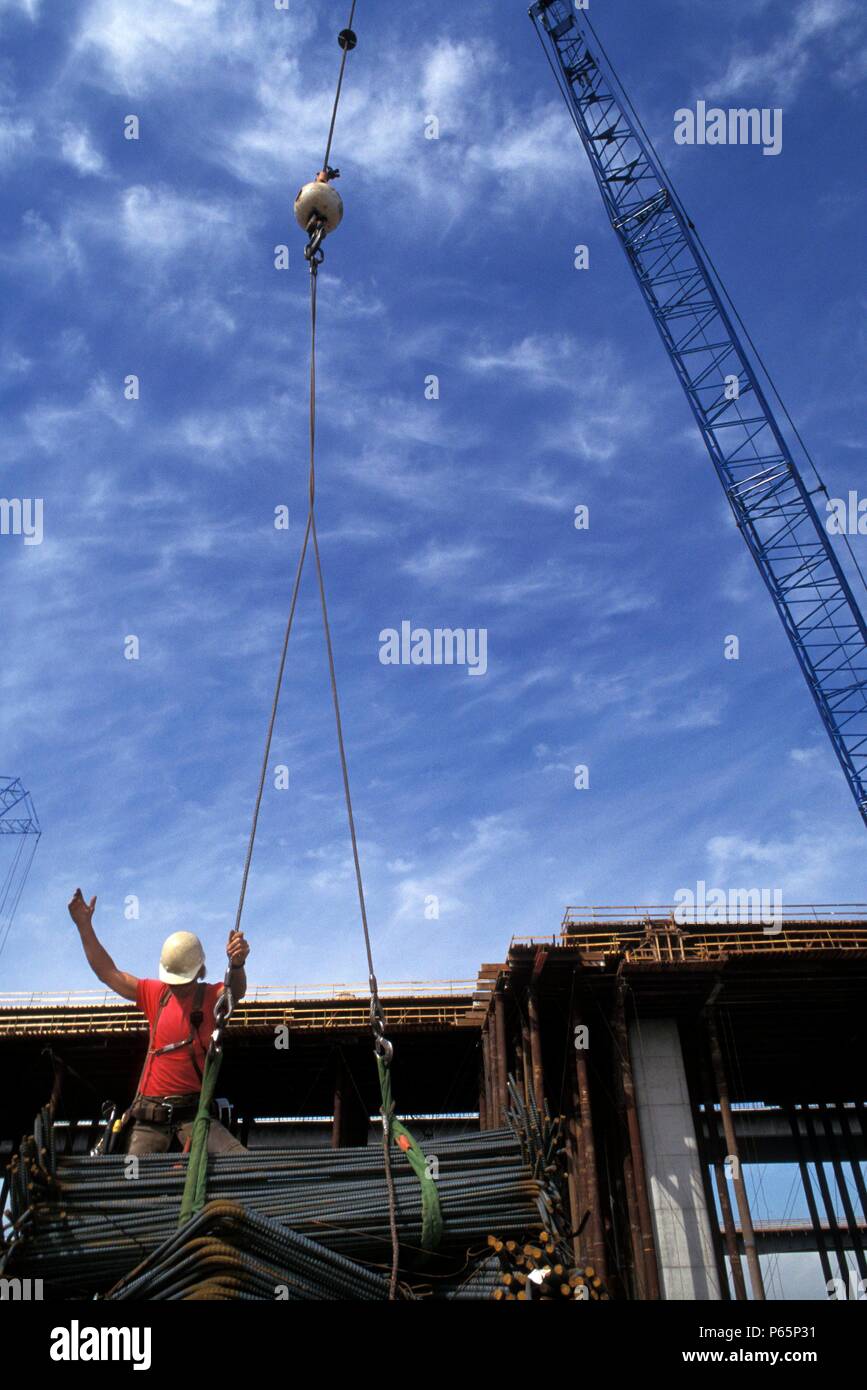 Ironworker signalling to crane operator to lift bundle of rebar Stock Photo Alamy