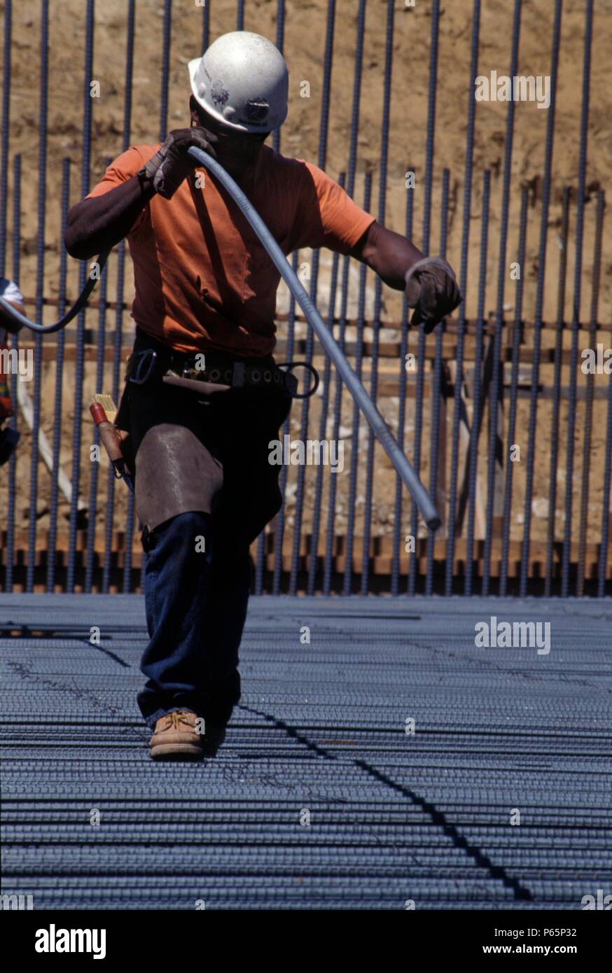 Ironworker carrying part of heavy rebar Stock Photo Alamy