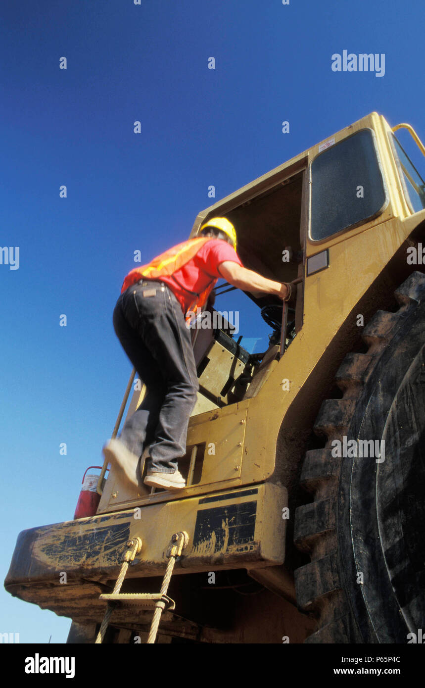 Operator climbing into cab of scraper, Lincoln, California, USA Stock ...