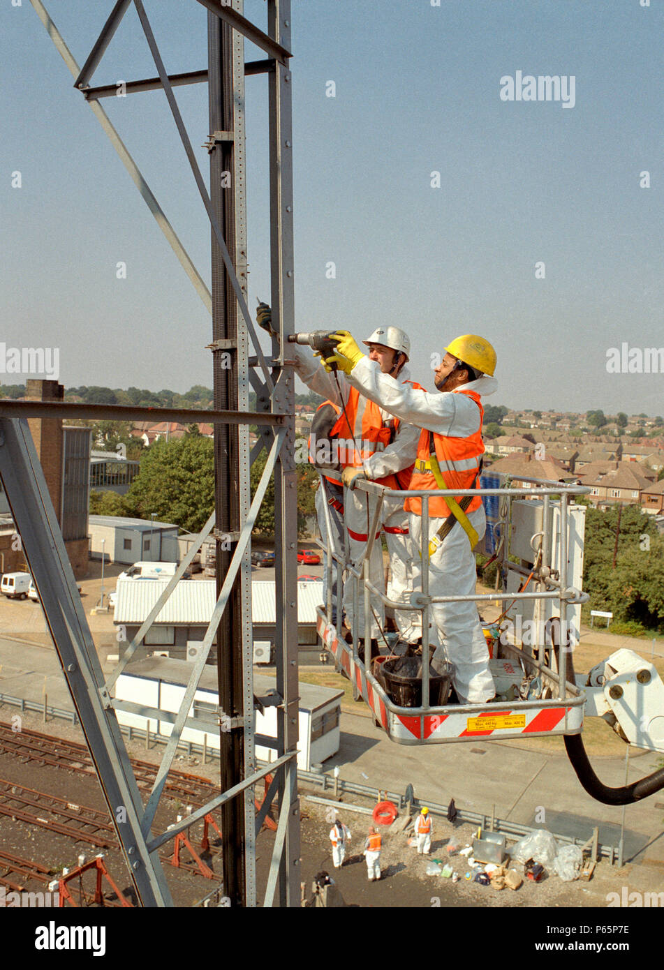 Two workers in safety equipment working at heights on an electricity