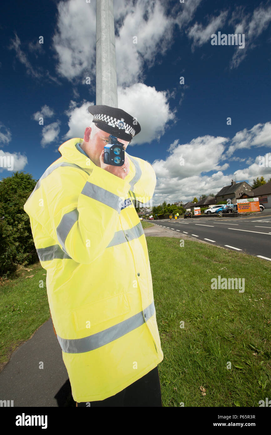 A life-sized cut out of a police officer, attached to a lamp post, holding a speed camera on the outskirts of the large village of Milnthorpe in Cumbr Stock Photo