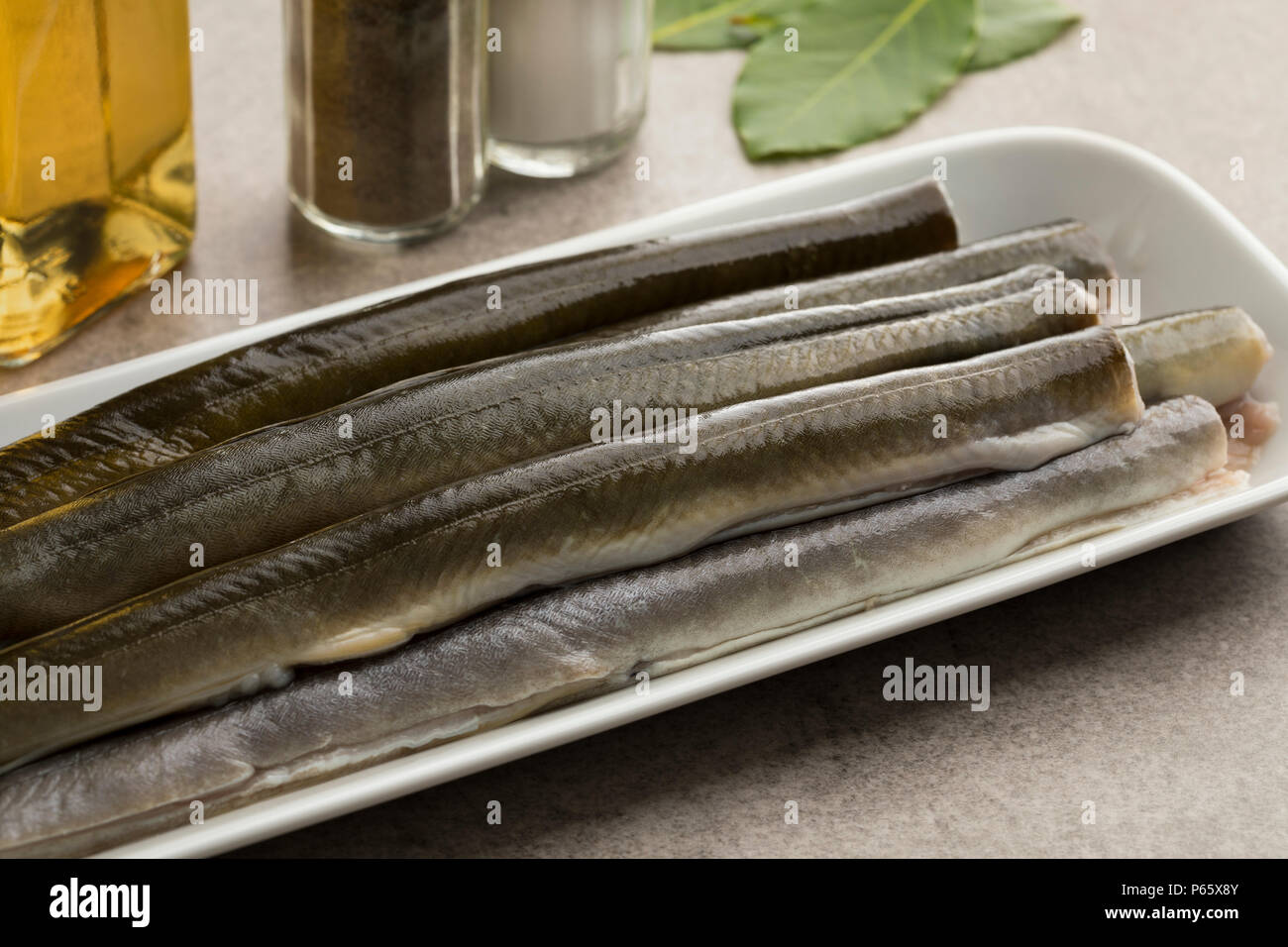 Fresh cleaned raw eels on a dish ready to cook Stock Photo