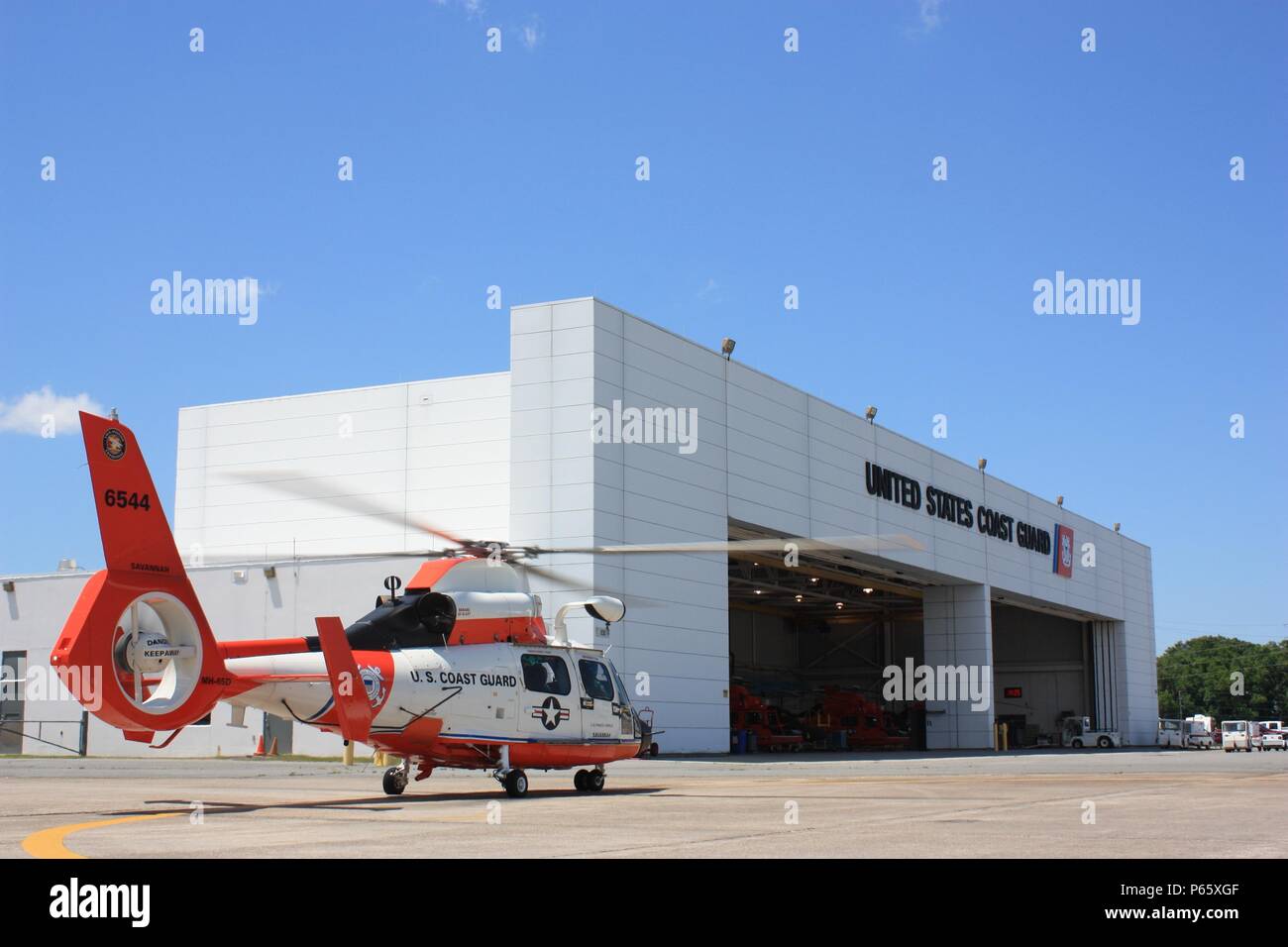 A specially-painted MH-65 Dolphin helicopter sits outside the hangar of Coast Guard Air Station Savannah, Georgia, May 4, 2016, in preparation for the unit’s observance of 100 years of Coast Guard aviation. This helicopter is one of nine to display this particular paint scheme, reminiscent of many early Coast Guard helicopters. U.S. Coast Guard photo by Lt. Trent Meyers Stock Photo