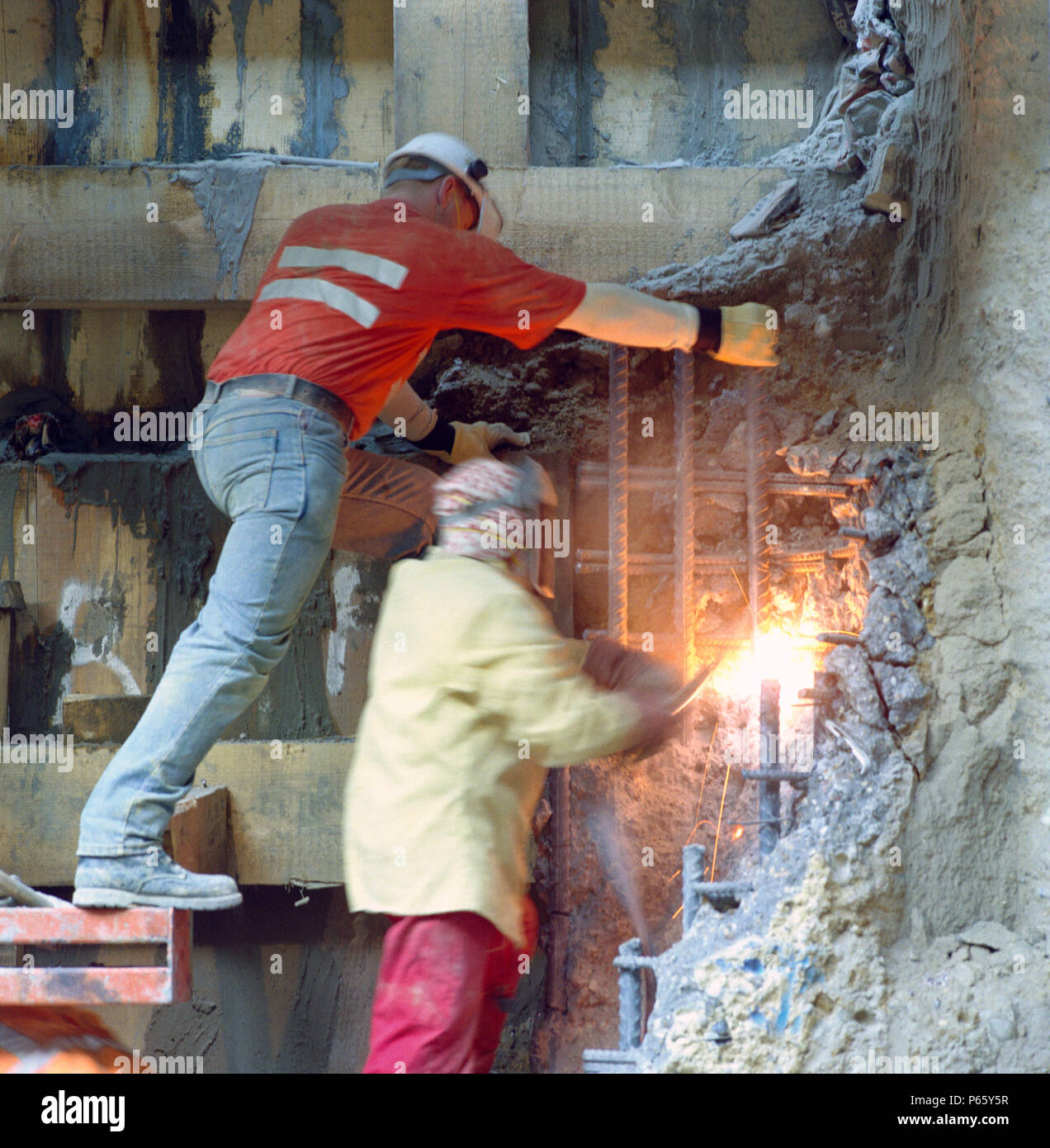 Using gas torch to cut steel reinforcing bars in concrete structure
