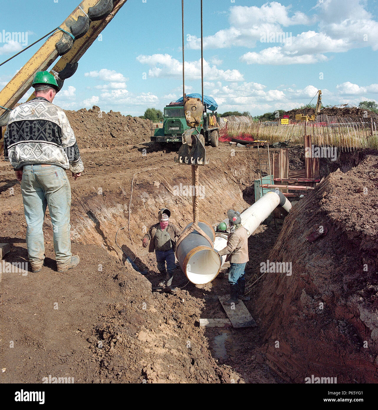 Positioning bend section of gas supply pipe in trench on the Essex marshes for the Barking Reach Power Station, the largest of the 1990s Dash For Gas  Stock Photo