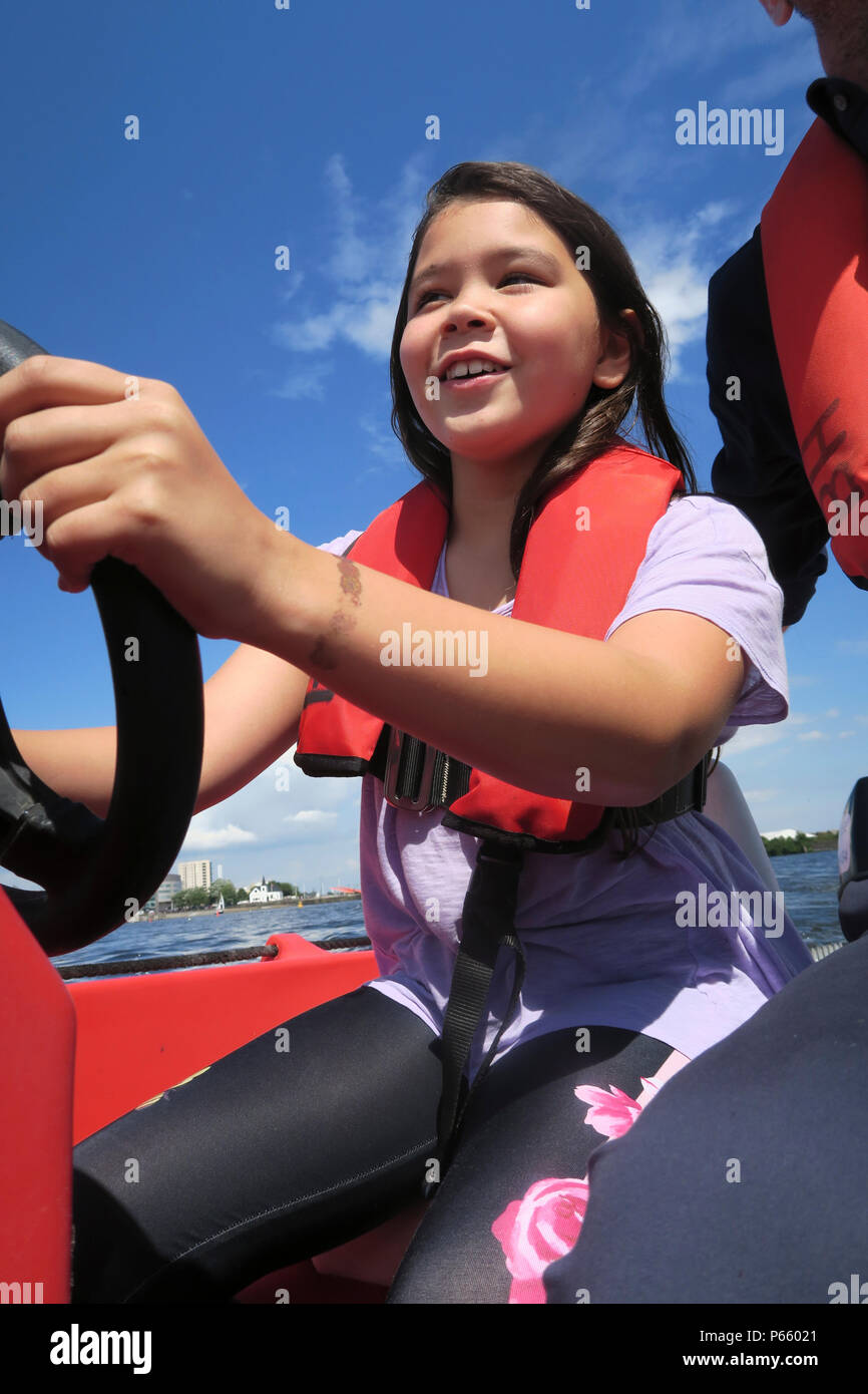 Young girl having fun steering a boat in Cardiff Stock Photo Alamy
