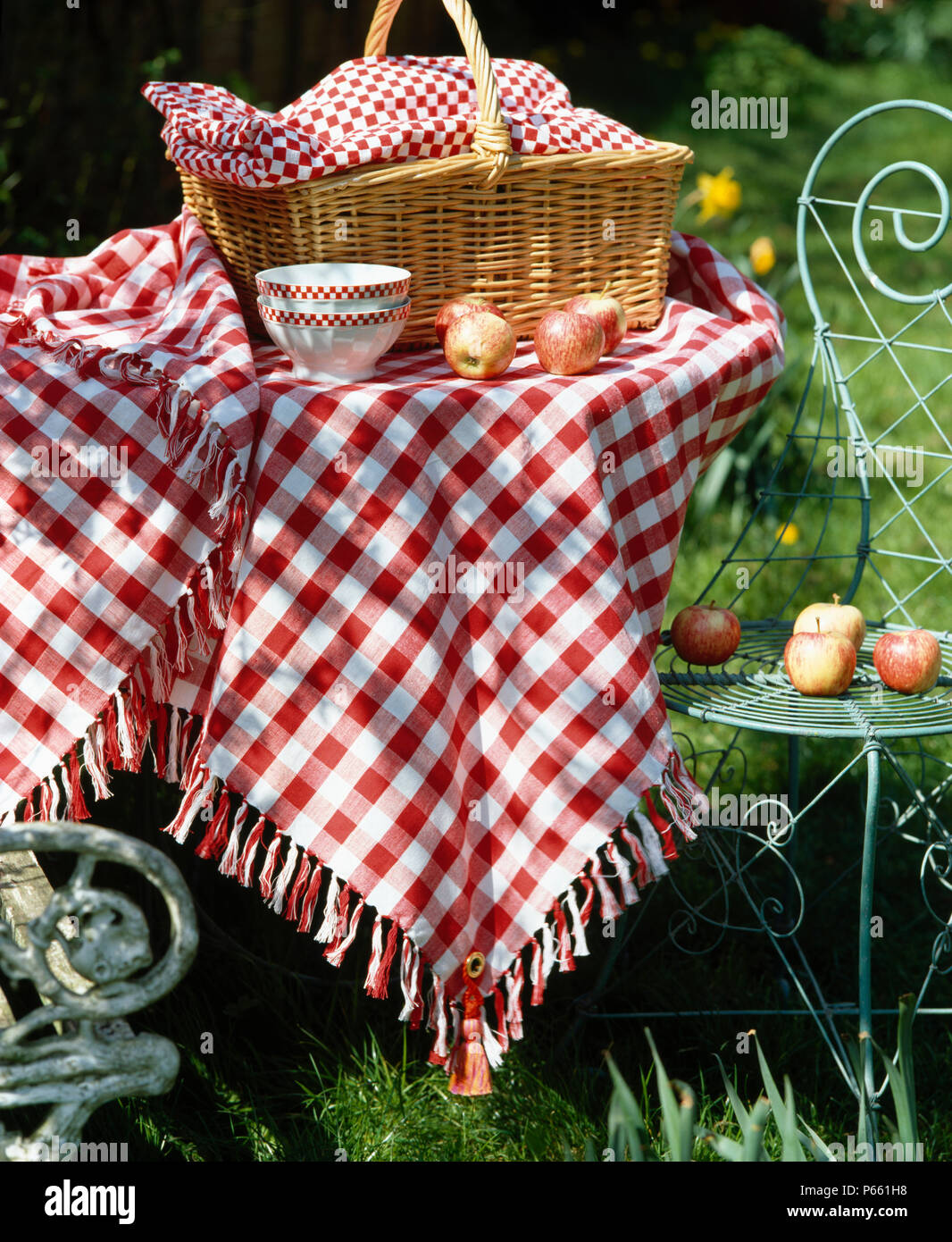 Close-up of willow basket on garden table with hand-made red checked cloth Stock Photo