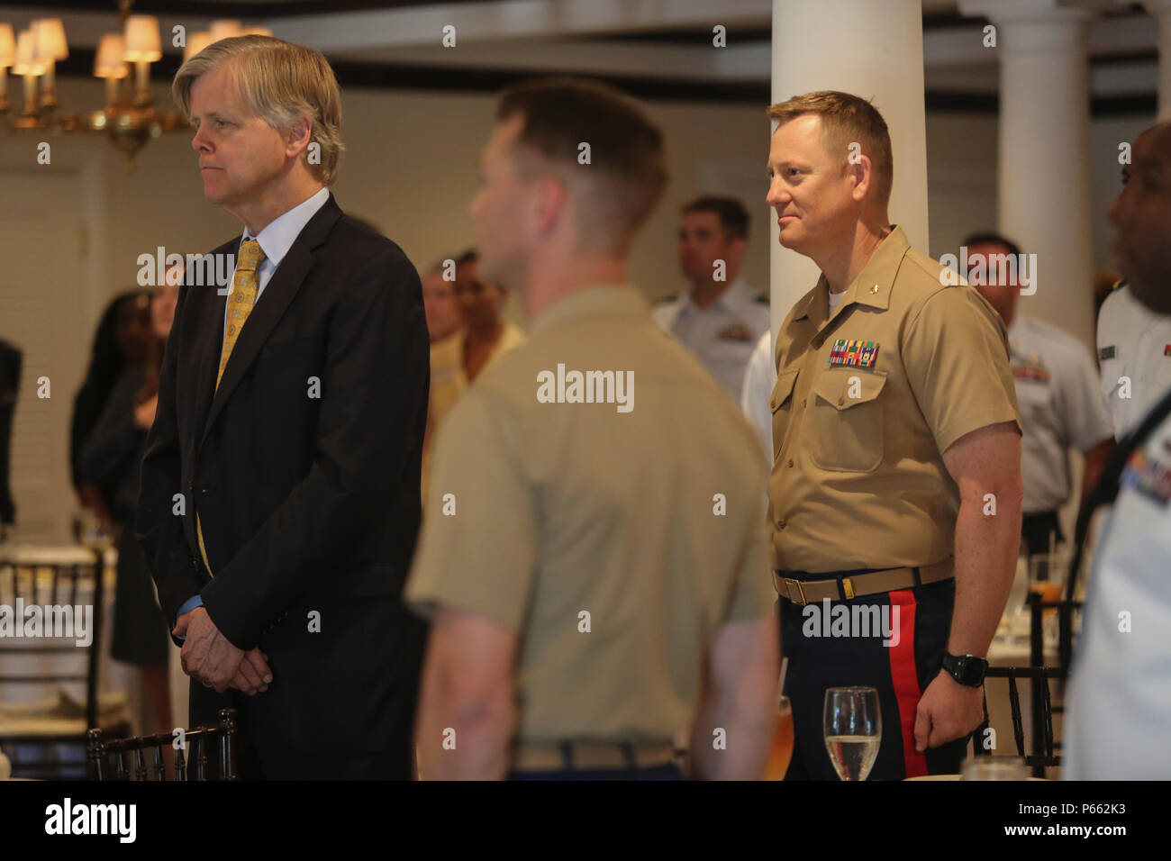Maj. Andre LaTaste, the Marine Forces Command programing officer, stands at attention with the Port Everglades Association while the National Anthem is sung during a Fleet Week luncheon, May 6, 2016. Fleet Week, which takes place in Fort Lauderdale, Fla., from May 2-8, will give the community of South Florida the opportunity to interact with the Marines and Sailors of the ship as well as see up-close and personal some of the capabilities and equipment the Marine Corps employs. (U.S. Marine Corps photo by Cpl. Michelle Reif/Released.) Stock Photo