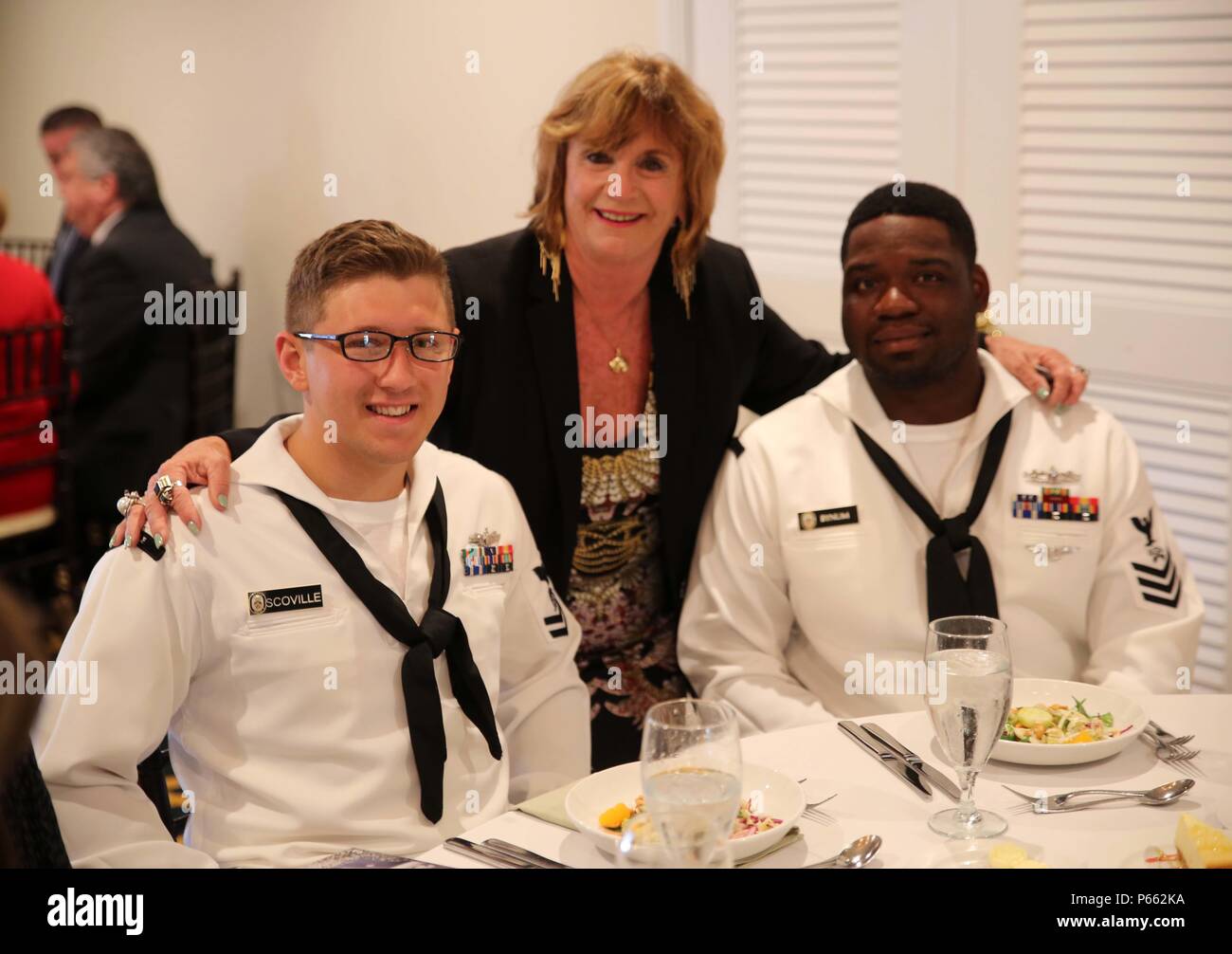Mary Anne Gray, a Broward Navy Days leader, poses for a picture with some Sailors from the USS Bataan during the Port Everglades Association Luncheon as a part of Fleet Week Port Everglades, Fort Lauderdale, Fla., May 6, 2016. Fleet Week will give the community of South Florida the opportunity to interact with the Marines and Sailors of the ship as well as see up-close and personal some of the capabilities and equipment the Marine Corps employs. (U.S. Marine Corps photo by Lance Cpl. Brianna Gaudi/Released.) Stock Photo