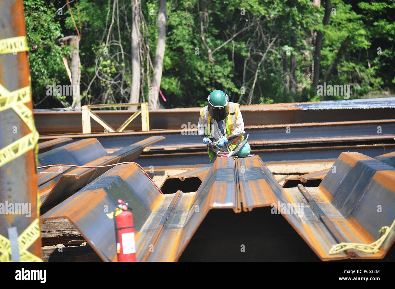 A worker with CDM Constructors uses a torch to cut a section of a steel coffer dam pile. CDM Constructors is the prime contractor for the dissolved oxygen injection system, an environmental mitigation feature of the Savannah Harbor Expansion Project (SHEP). The coffer dam will allow workers to build the site for a series of Speece cones. These cones will super-oxygenate river water and inject it back into the Savannah River to maintain current levels of dissolved oxygen as the shipping channel is deepened. The U.S. Army Corps of Engineers, Savannah District, oversees the SHEP, including enviro Stock Photo