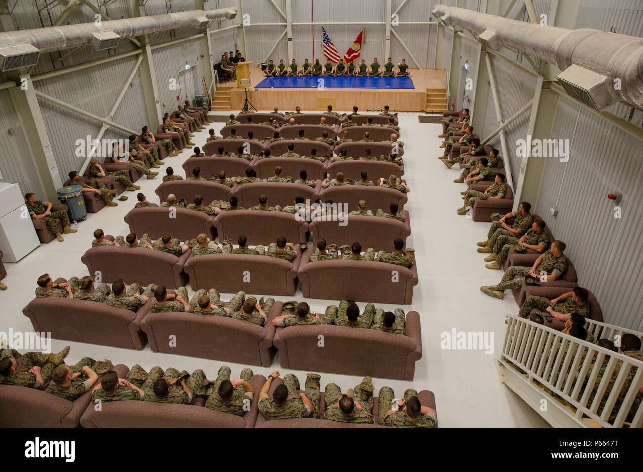 Twelve U.S. Marines with Black Sea Rotational Force sit cross-legged on mats during the Marine Corps Martial Arts Instructor graduation ceremony for class 155-16, aboard Mihail Kognalniceanu Air Base, Romania, April 22, 2016. These graduates spent a three weeks enduring physical training sessions, learning how to correctly give hip-pocket classes, and how to properly teach techniques of all belt levels of the Marine Corps Martial-Arts Program. (U.S. Marine Corps photo by Cpl. Kelly L. Street, 2D MARDIV COMCAM/Released) Stock Photo