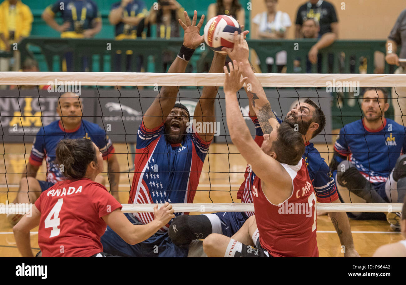 U.S. Army veteran Alexander Shaw, left center, and U.S. Air Force veteran Nicholas Dadgostar, right center play the ball against Canada during sitting volleyball competition during Invictus Games 2016 at the ESPN Wide World of Sports complex at Walt Disney World, Orlando, Fla., May 7, 2016. Also pictured are U.S. Special Operations Command Sgt. 1st Class Alfred Martinez left, and U.S. Army veteran Robbie Gaup, right. The Invictus Games are the United Kingdom’s version of the Warrior Games, bringing together wounded veterans from 14 nations for events including track and field, archery, wheelch Stock Photo