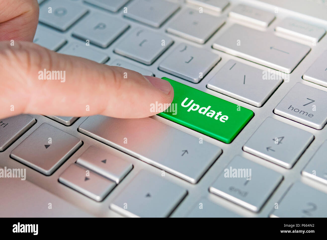 Computer notebook keyboard with Update key - technology background. update inscriptions on the grey silver keyboard button close up, green button. Stock Photo