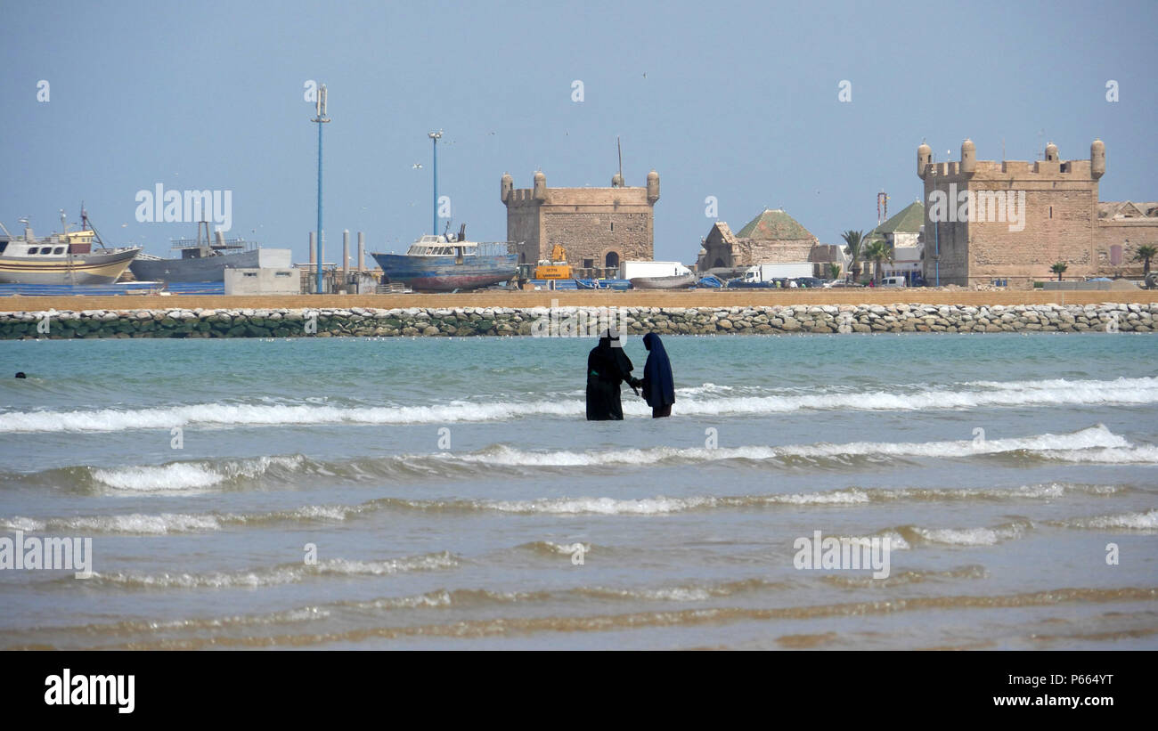 two young Islamic girls wearing Hijab enjoying the sea at Essaouira beach Stock Photo