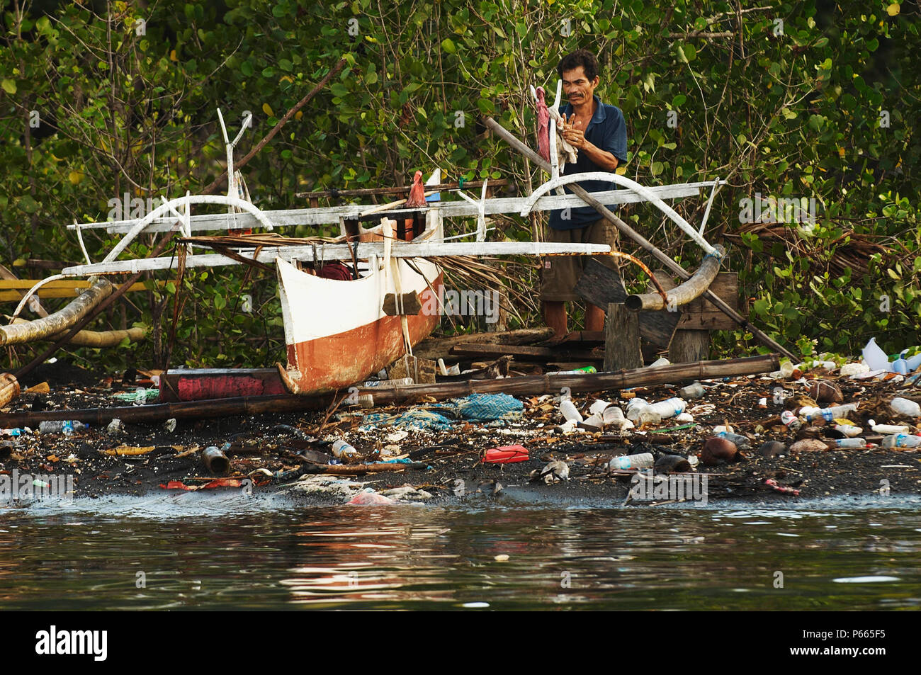 Indonesia, North Sulawesi, near Bitung, Lembeh Strait, Jukung, pollution on the beach. Stock Photo