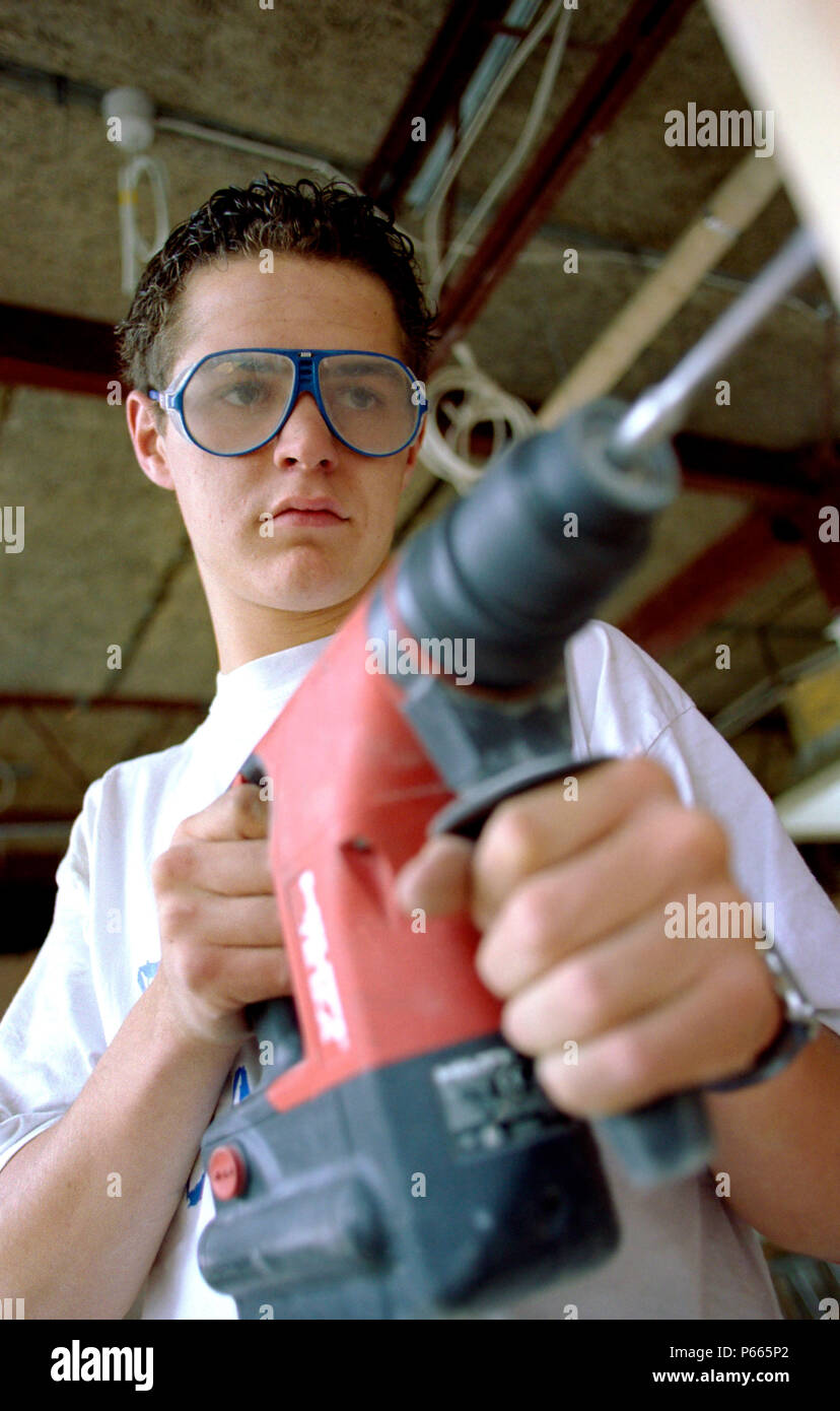 Young builder using a power drill. Stock Photo