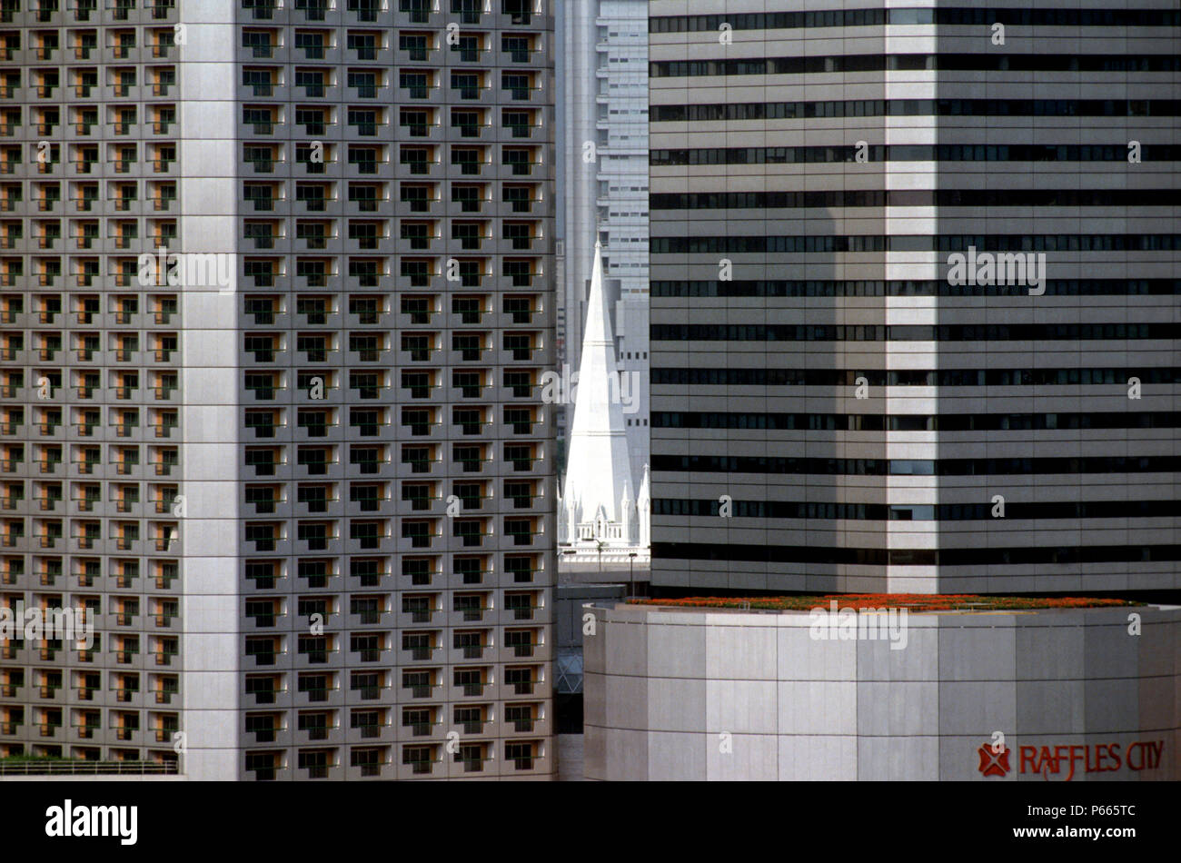 Modern towers of the Raffles Commercial Centre surrounding the old Victorian church, Singapore Stock Photo