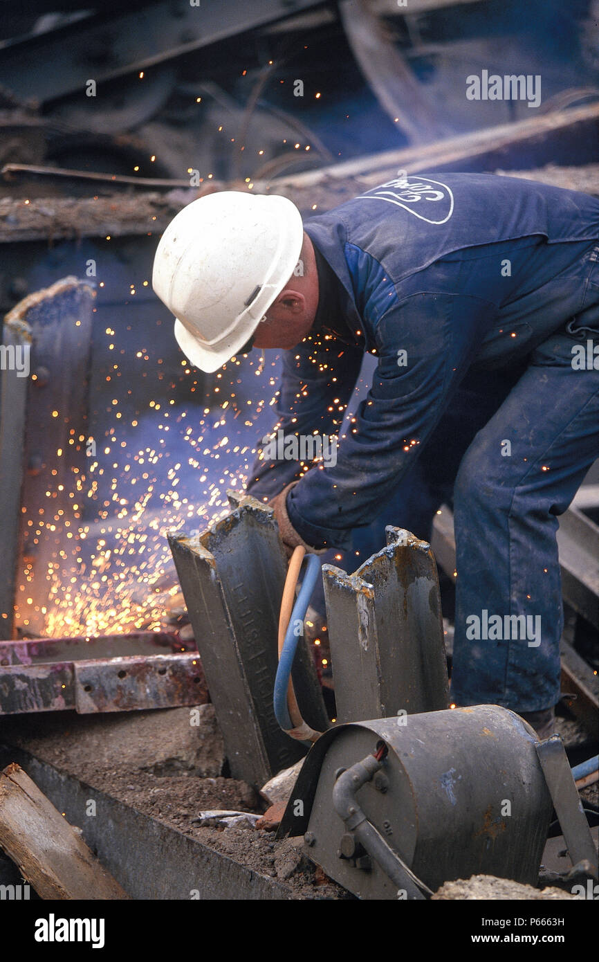 Worker using gas torch to cut up scrap metal Stock Photo - Alamy