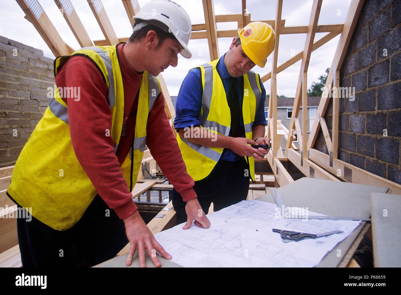 Construction workers reviewing plans on site. Stock Photo