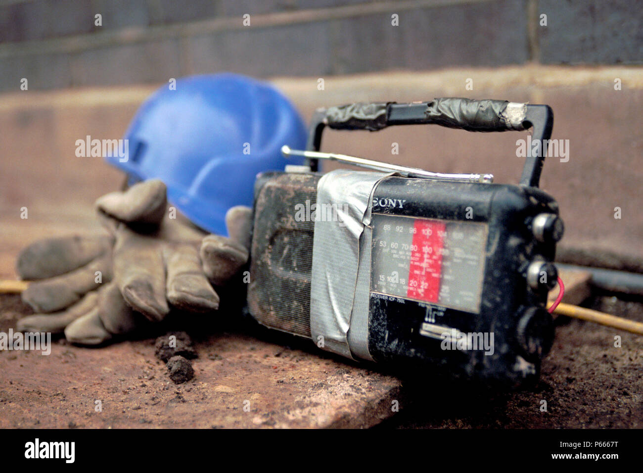 Detail of a hard hat, gloves and a radio on-site. Stock Photo