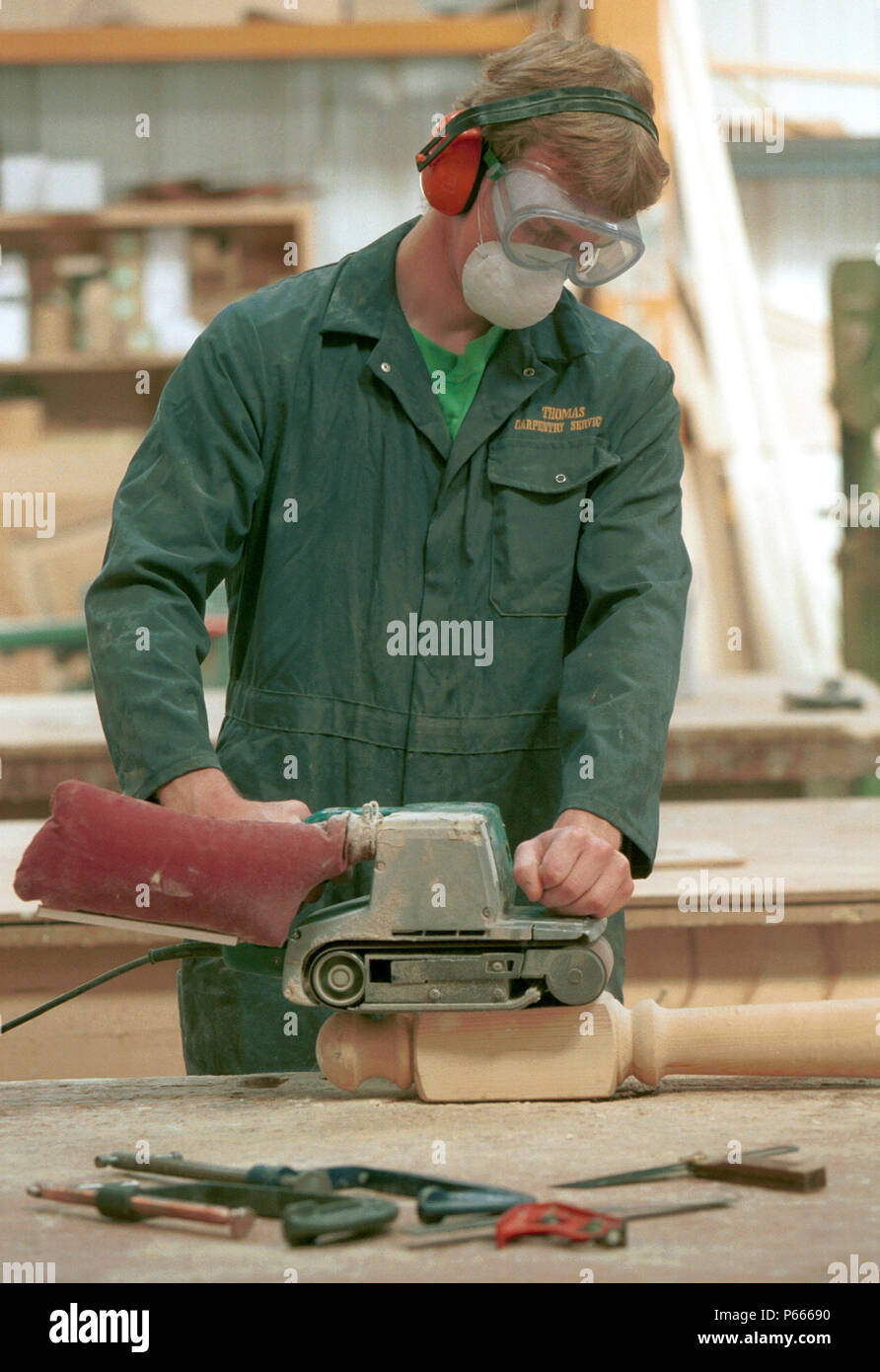 Woodmachining. Operative using a electrical belt sander Stock Photo Alamy