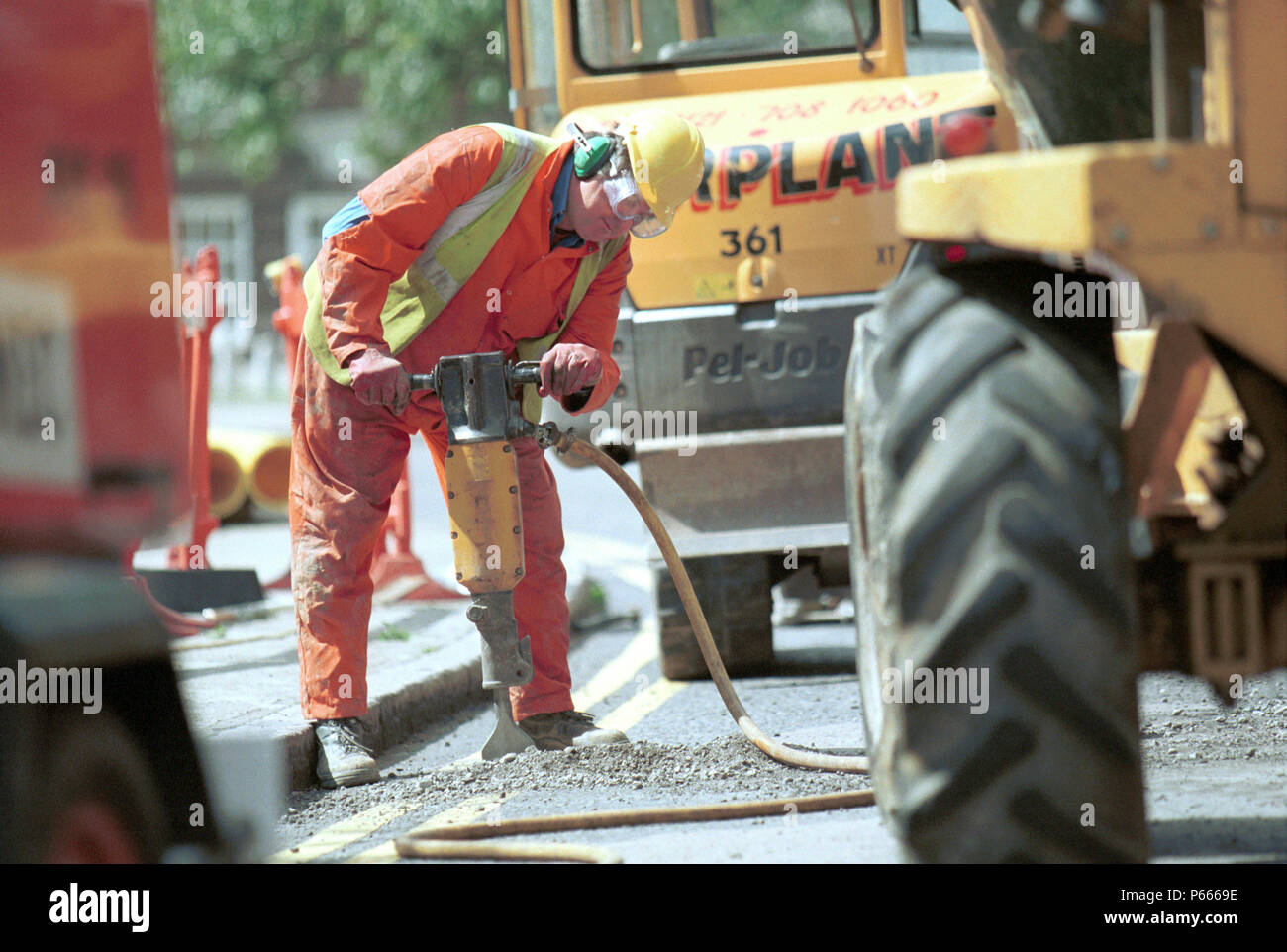 Public Utilities. Man working on a road with a jack hammer Stock Photo