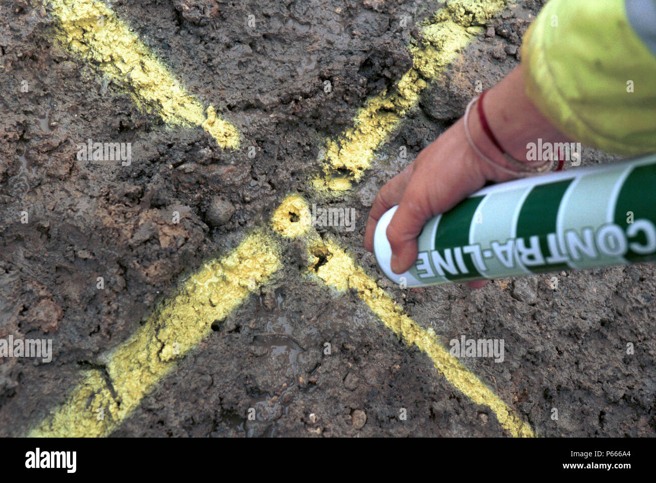 Surveying. Marking a yellow cross on the ground. Stock Photo