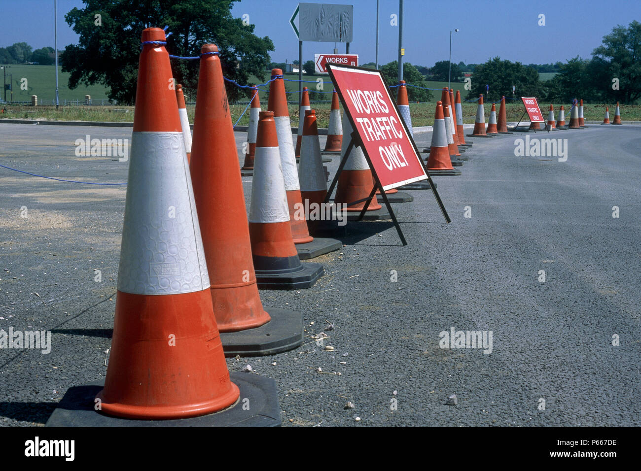 Traffic cones separating  construction site and works access from public highway during construction of Great Leighs bypass. Essex, United Kingdom. Stock Photo