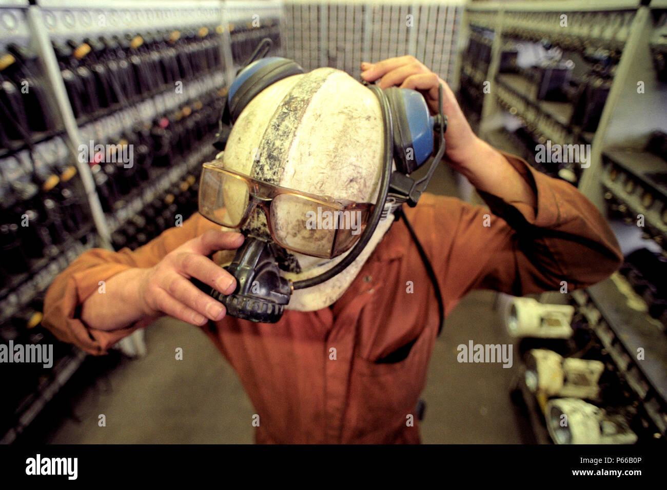 A miner puts on his hard hat and light in the lamp room, Tower Colliery