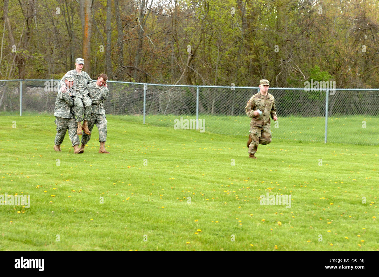 Soldiers of the 144th Military Police Company, 210th MP Battalion, 177th MP Brigade, Michigan National Guard, compete in the arm chair carry portion of the Blackhats' Last Charge held in Corunna, Mich., May 7, 2016. The Blackhats' Last Charge is a competition in which Soldiers compete in three-person teams against each other through a three-mile road march and a series of physical team events that include a Sackman's race, tow bar carries, tow bar squats, Meal Ready to Eat sit-ups, team triangle push-ups, burpees, and a HMMWV push. The 144th MP Co. is being divested as part of a force structur Stock Photo