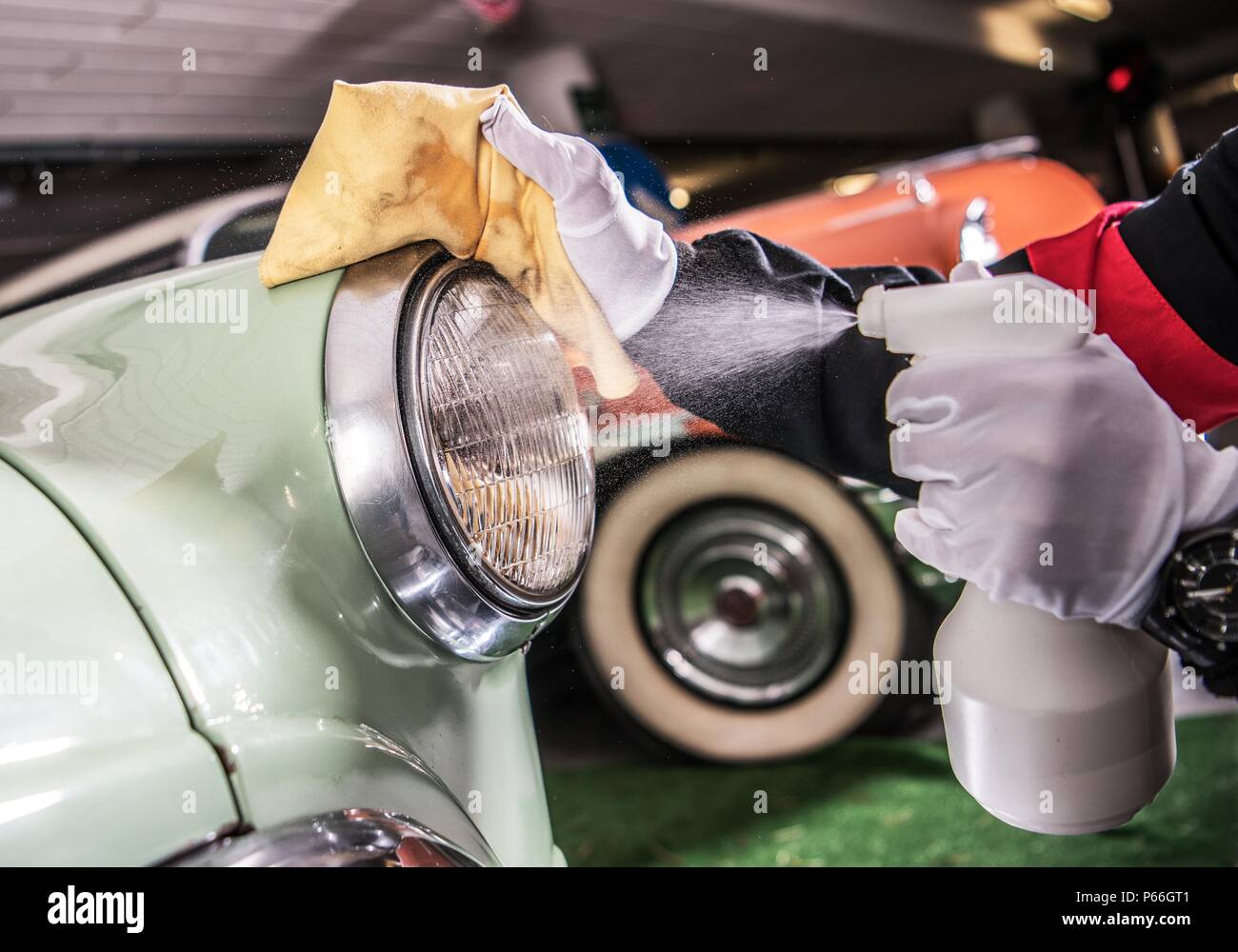 Vintage Car Cleaning and Detailing. Worker Spraying Cleaning Liquid on the  Car Body Stock Photo - Alamy