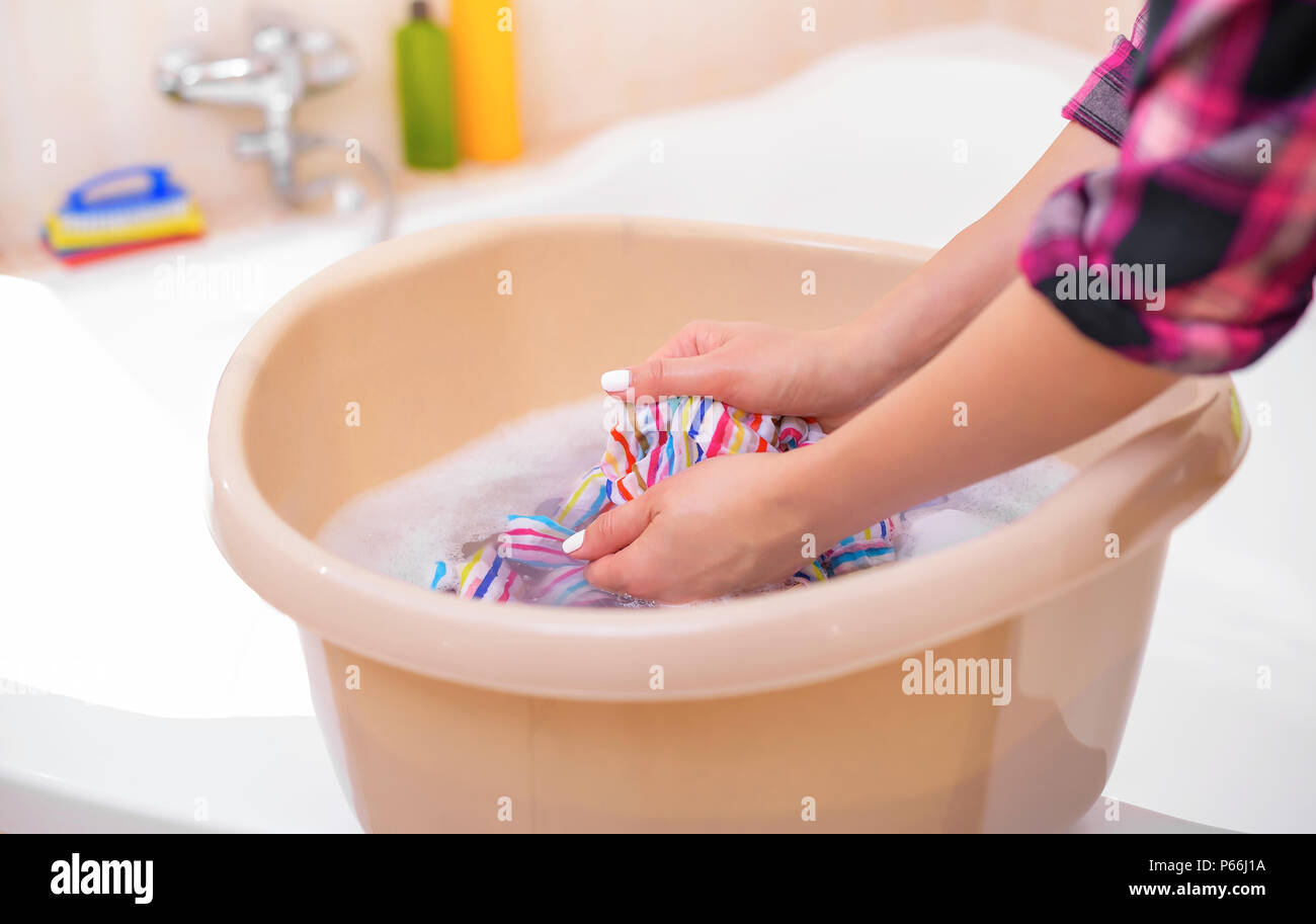 Women's hands wash clothes in the basin. Stock Photo