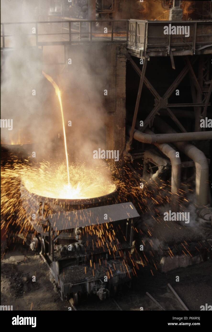 Molten waste from the blast furnaces being poured into ladle wagons prior to being taken to be empted down the slag bank located on the periphery of t Stock Photo