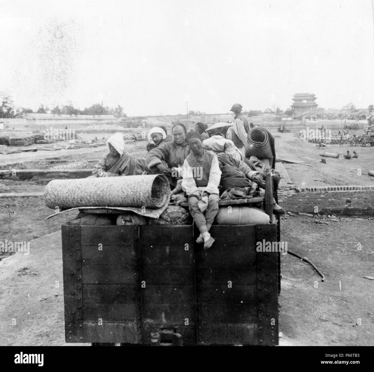 Chinese Christians sitting on their belongs, which are piled on a truck leaving Peking, China in the time of the Boxer Rebellion c1902. Stock Photo