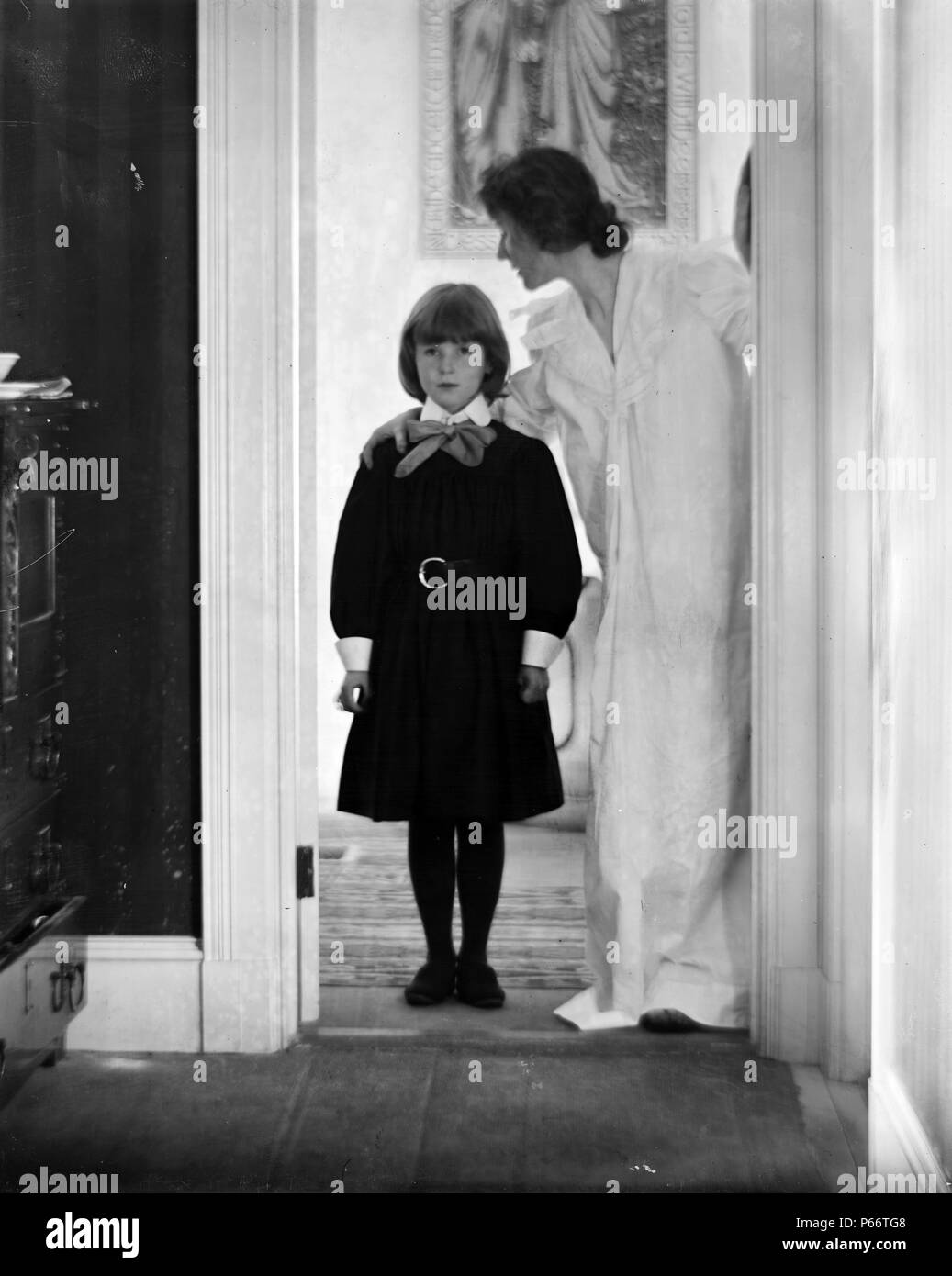 Blessed art thou among women by Photographer Gertrude Käsebier, 1852-1934. Photograph shows a mother and daughter standing in a doorway, with a picture of the Annunciation on the wall behind them. The young girl is Peggy Lee with her mother Agnes Lee (wife of Boston photographer Francis Watts Lee), probably at their home in Boston. Dated ca. 1900 Stock Photo