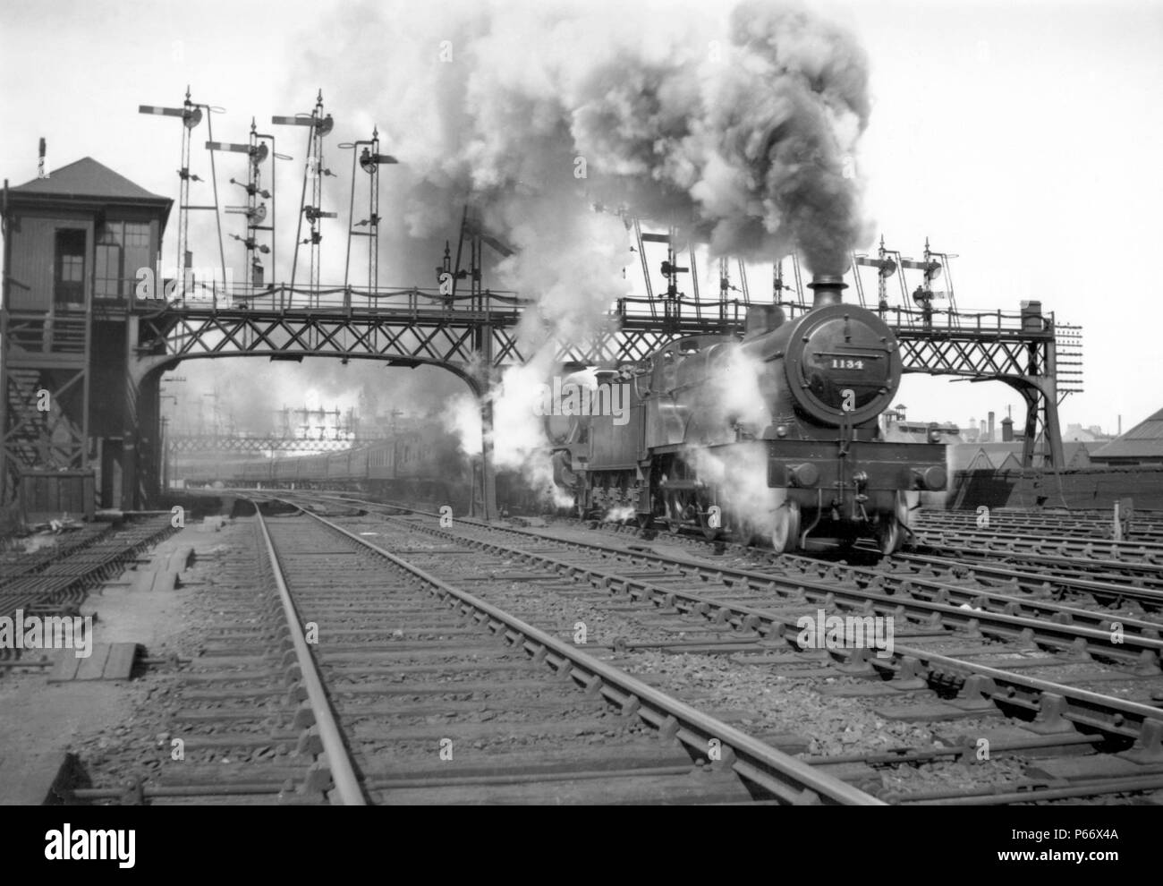 A former Midland Railway 4-4-0, three cylinder compound Class 4P piloting a double headed train past an impressive array of semaphore signals. C1955 Stock Photo