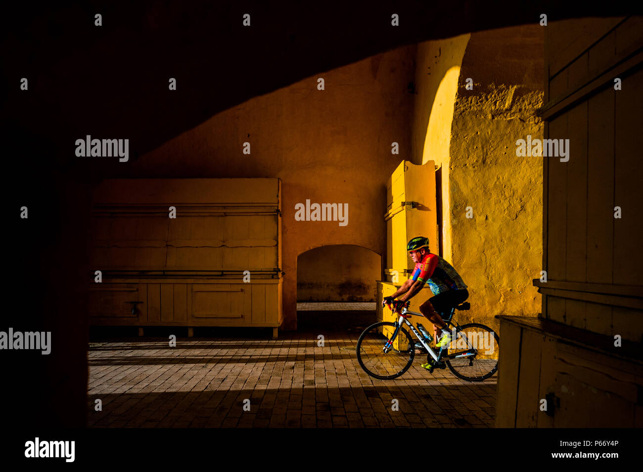 A Colombian cyclist rides his bicycle through the Clock Tower gate, the entrance to the colonial walled city in Cartagena, Colombia. Stock Photo