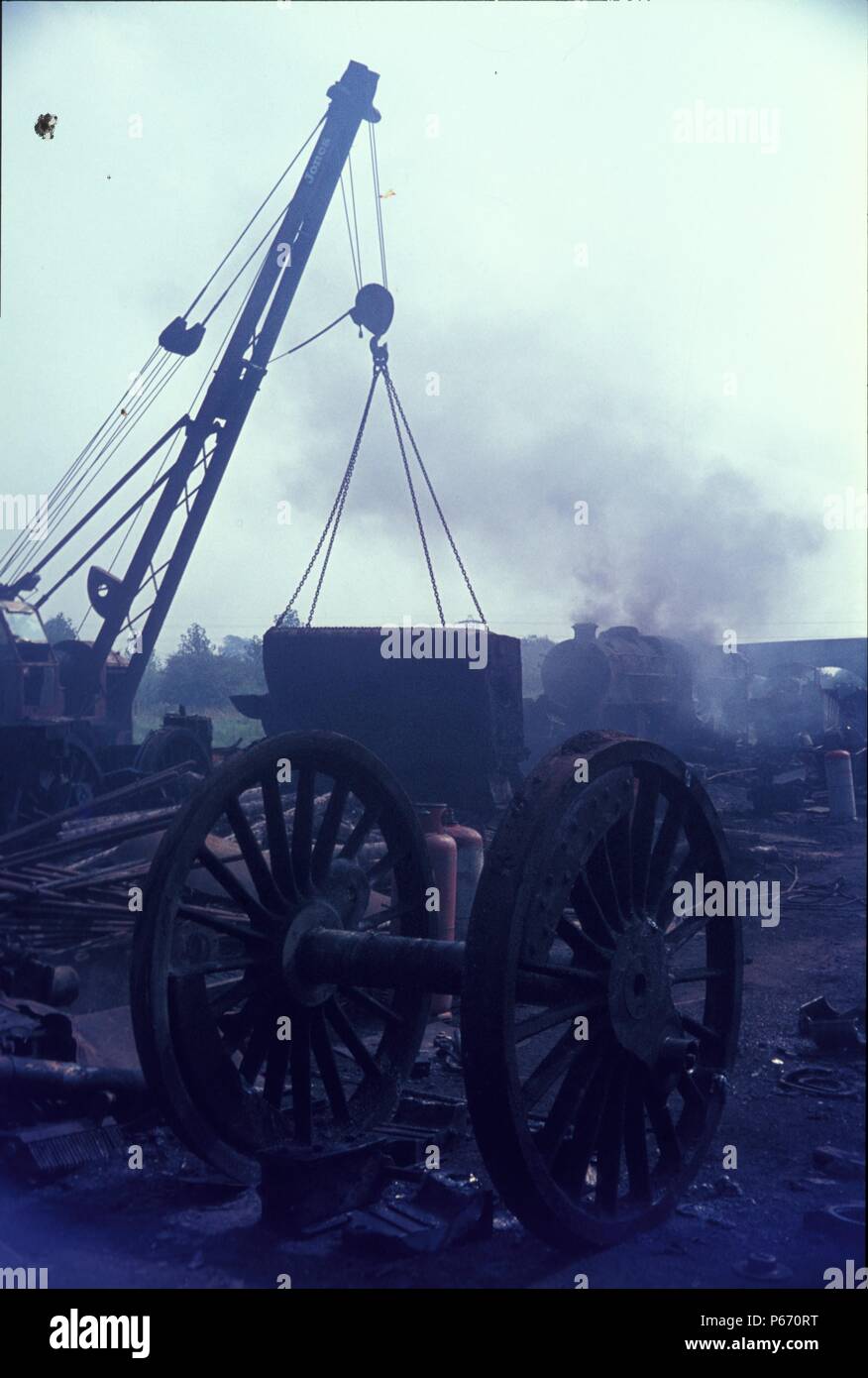 The six foot diameter of a Black Five's driving wheels are contrasted against a firebox at Cohen's Scrapyard, Kettering. Stock Photo