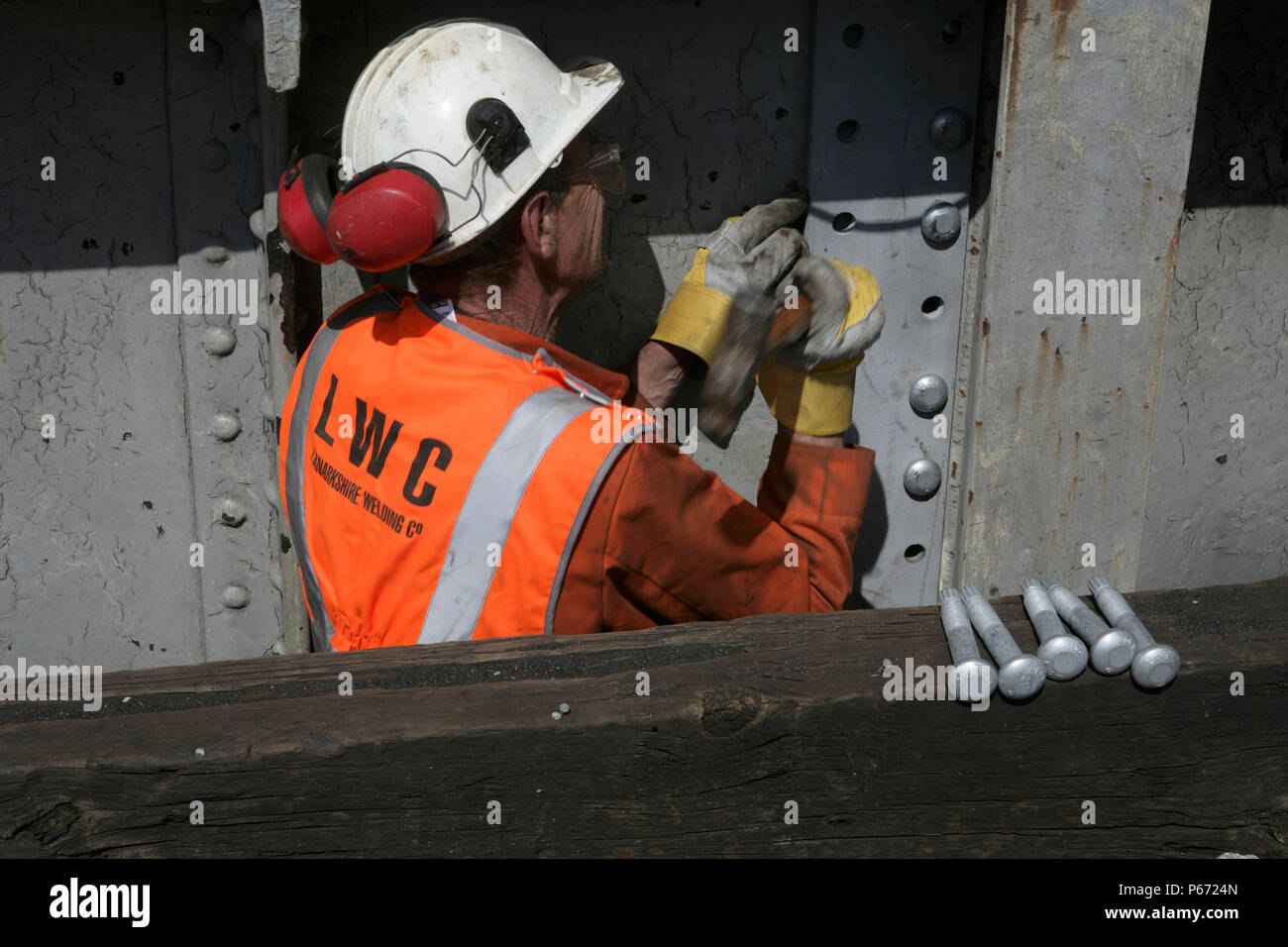 A railway worker replacing bolts during the refurbishment of a bridge