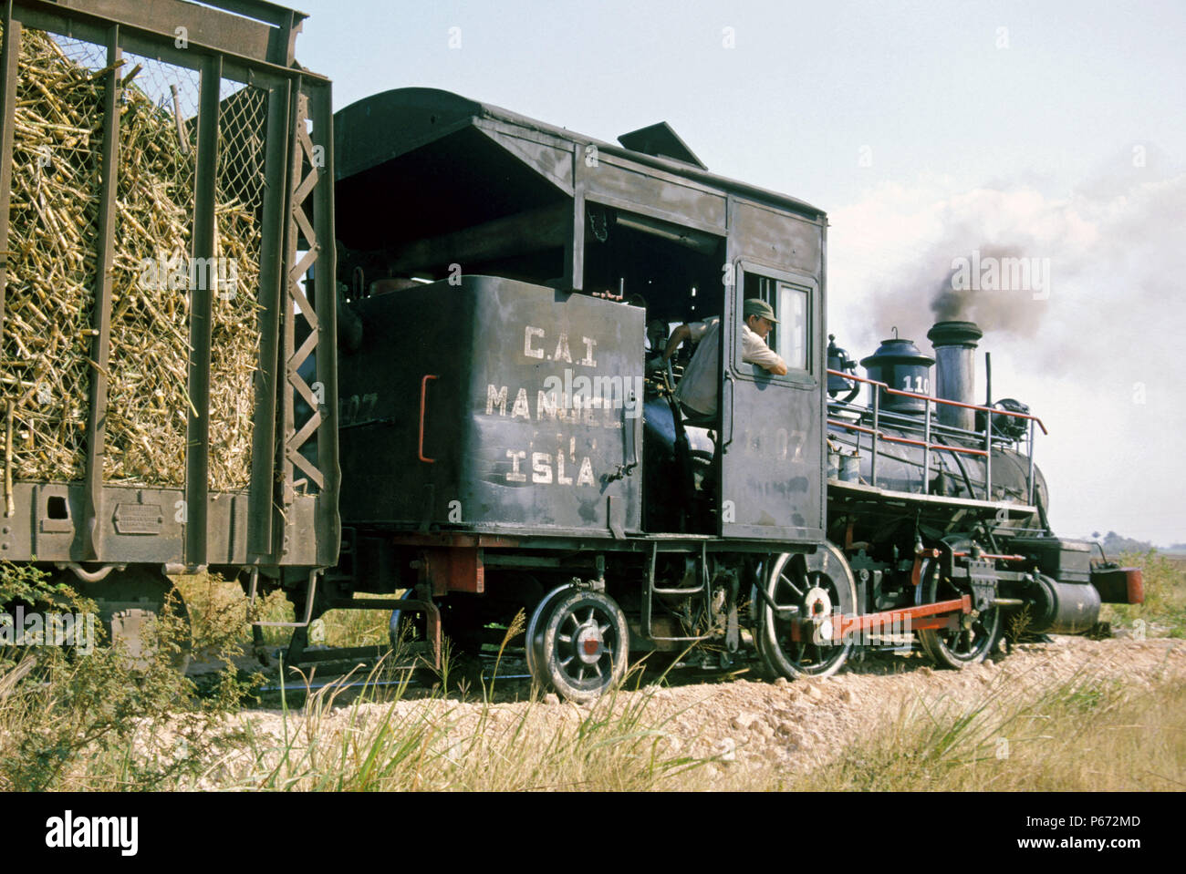 A vintage Baldwin 0-4-2T believed to be of 1882 vintage draws a rake of loaded sugar cane at the Manuel Isla Perez Sugar Mills Cuba. Stock Photo