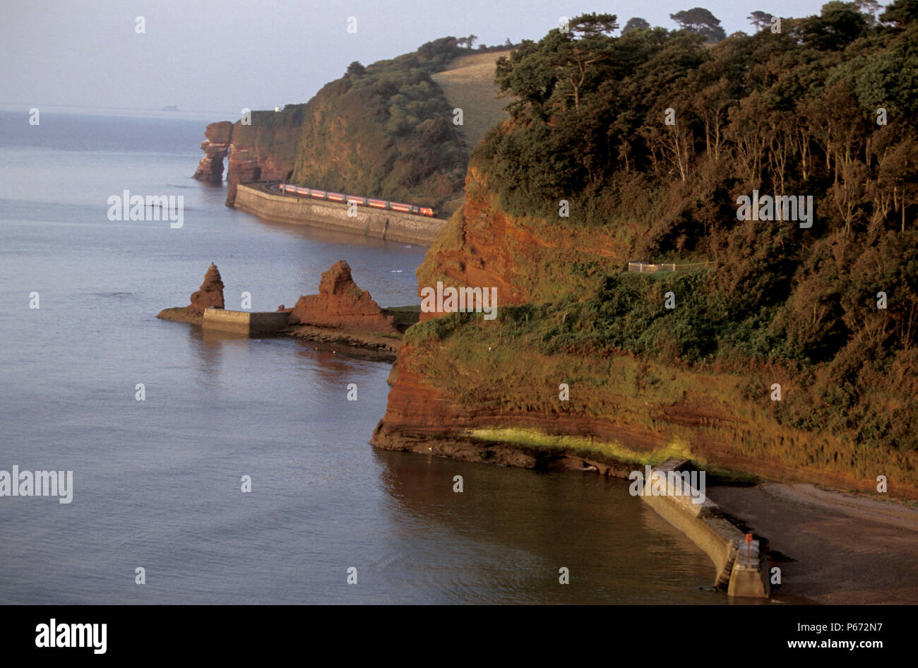 A Virgin Trains HST hugs the coast as it traverses the sea wall near to Dawlish in Devon with a CrossCountry service from Penzance. C2000 Stock Photo
