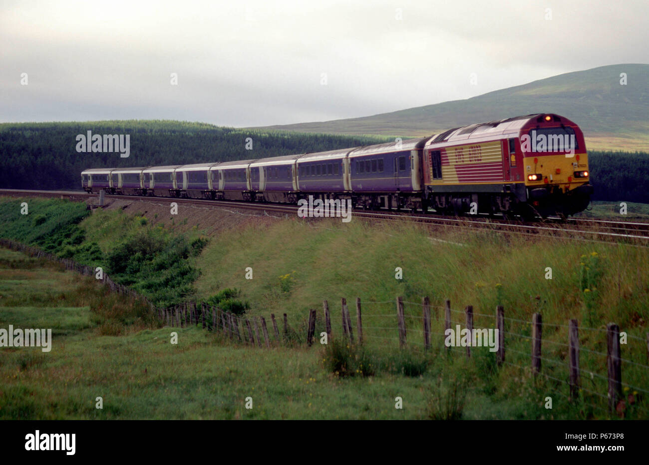 An EWS class 67 travels northbound through the Scottish countryside on approach to Dalwhinne station. This train started its journey at London and wil Stock Photo
