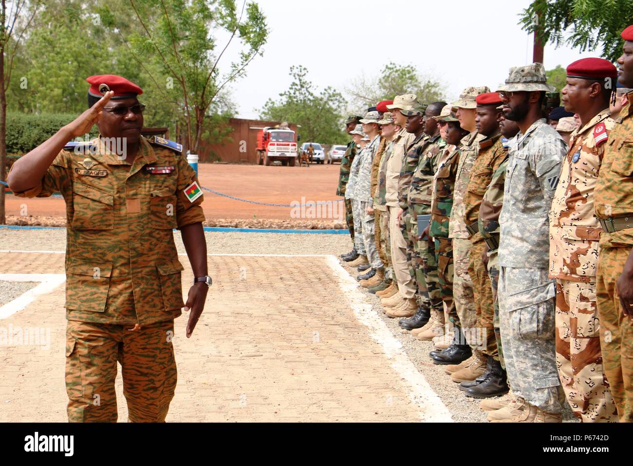 General Pingrenoma Zagre, Chief of Defense Staff for Burkina Faso Armed Forces, salutes multinational Western Accord 2016 participants during the exercise’s Closing Day Ceremony May 13, 2016 at Camp Zagre, Ouagadougou, Burkina Faso. The two-week command post exercise, which began May 2, brought together 15 West African Nations, 7 NATO European countries and the U.S. to work as a multinational headquarters to build interoperability and shared understanding. (U.S. Army photo by Staff Sgt. Candace Mundt/Released) Stock Photo