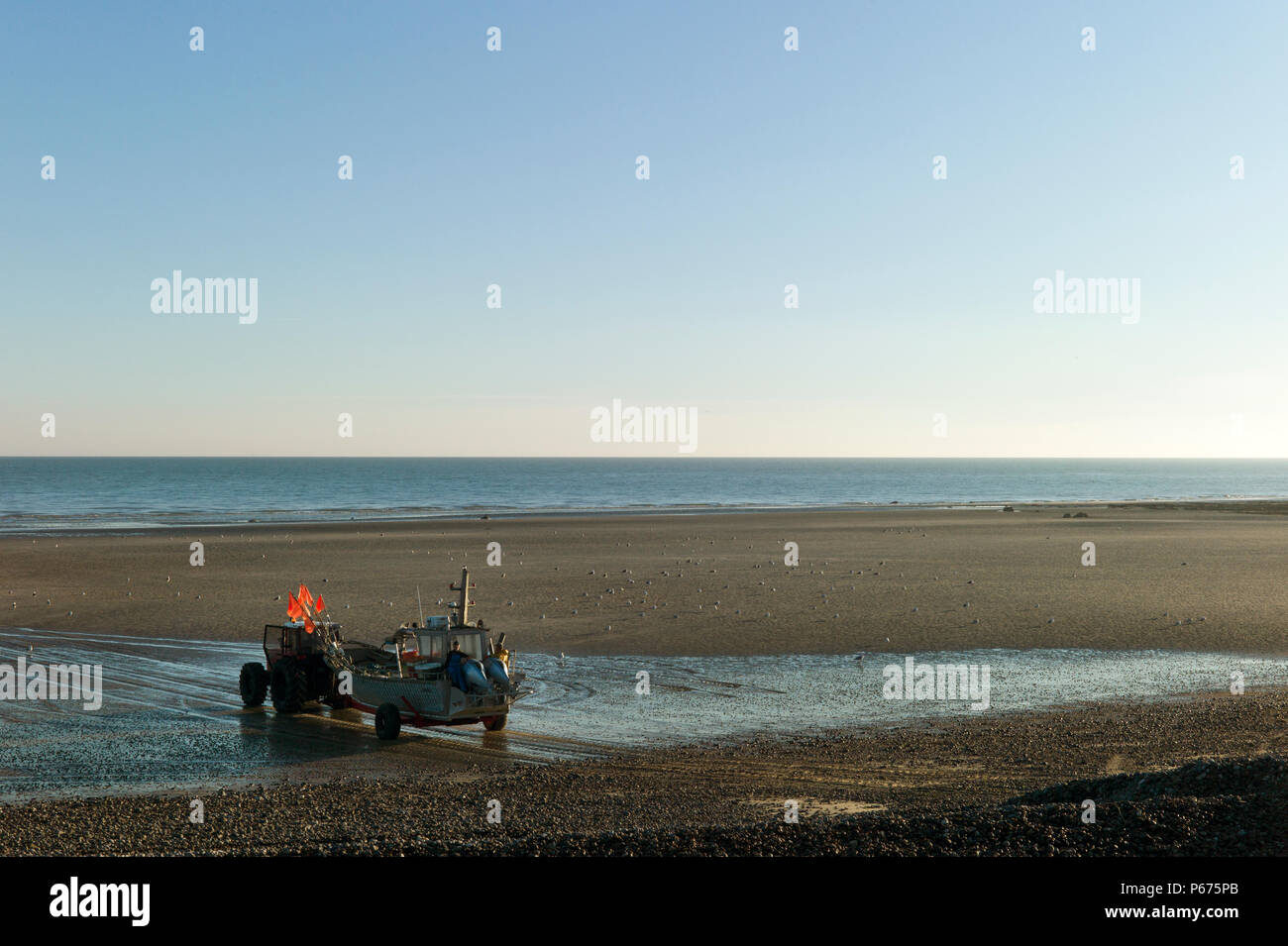 Small fishing boat being towed by tractor to launch, Normandy, France Stock Photo