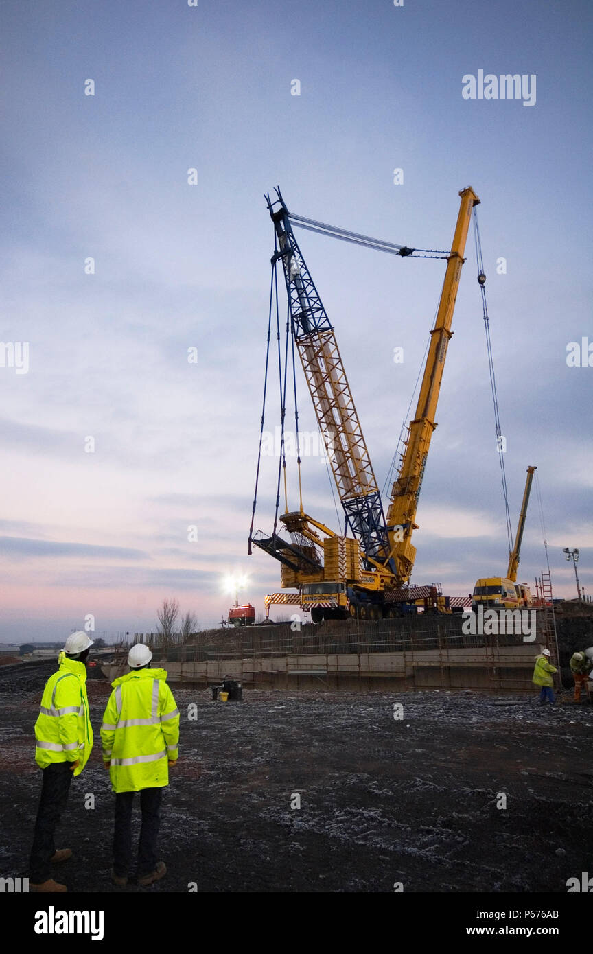 Construction engineers watching crane working on Upper Forth Crossing, Scotland Stock Photo