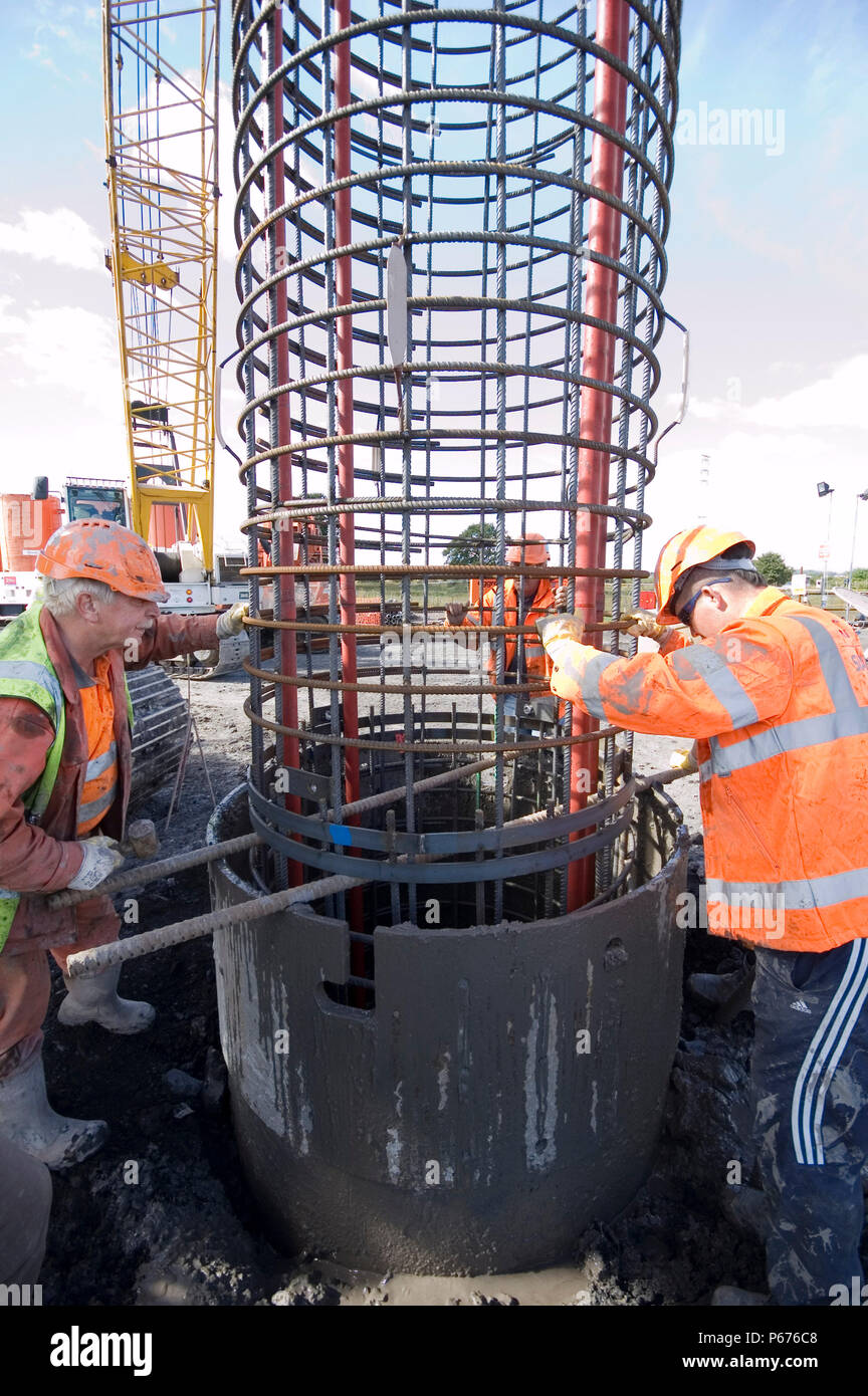 Construction crew at work fitting reinforcing into the piling Stock
