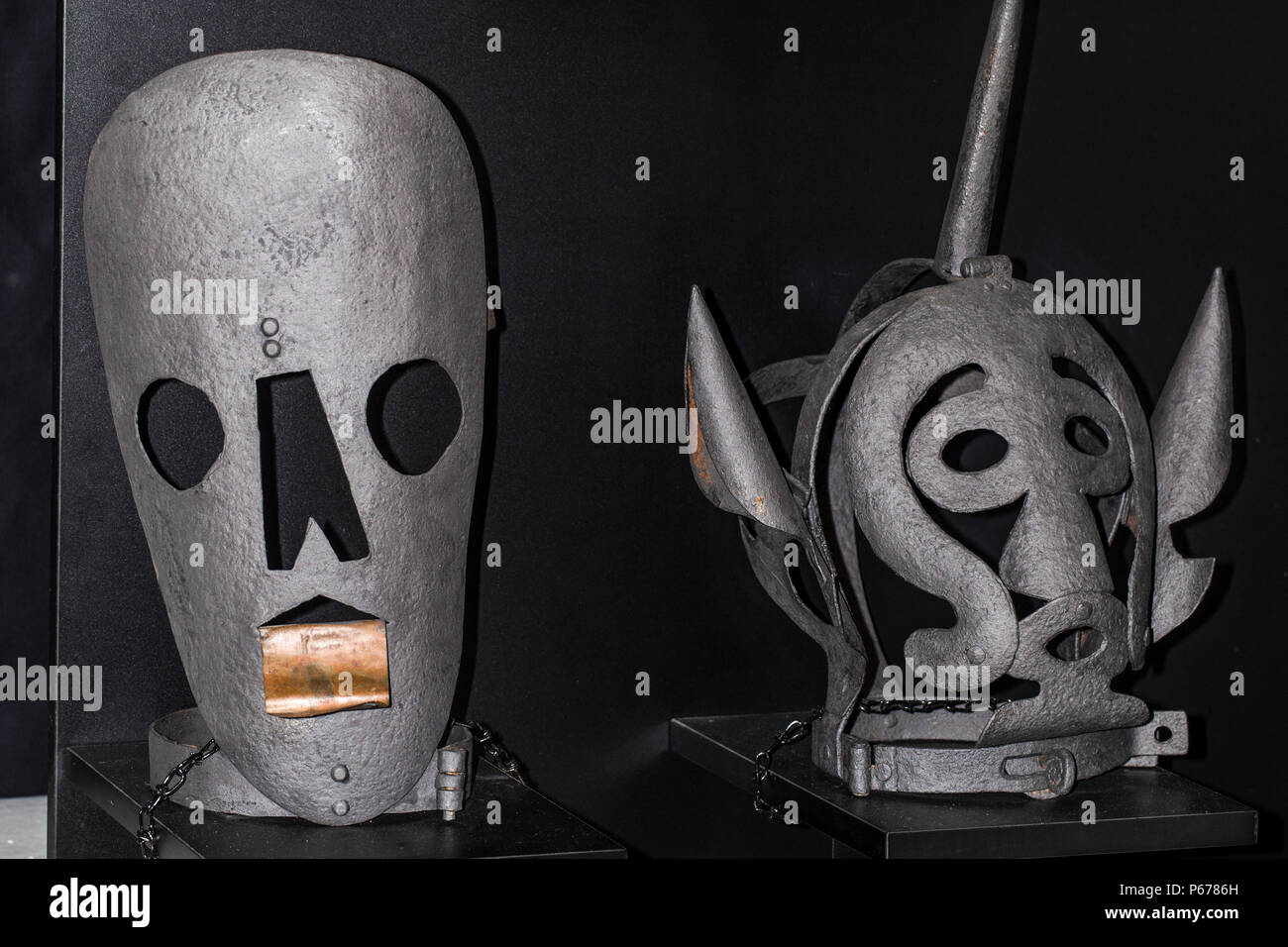 Instruments of torture times of inquisition two gray masks on a black background Stock Photo
