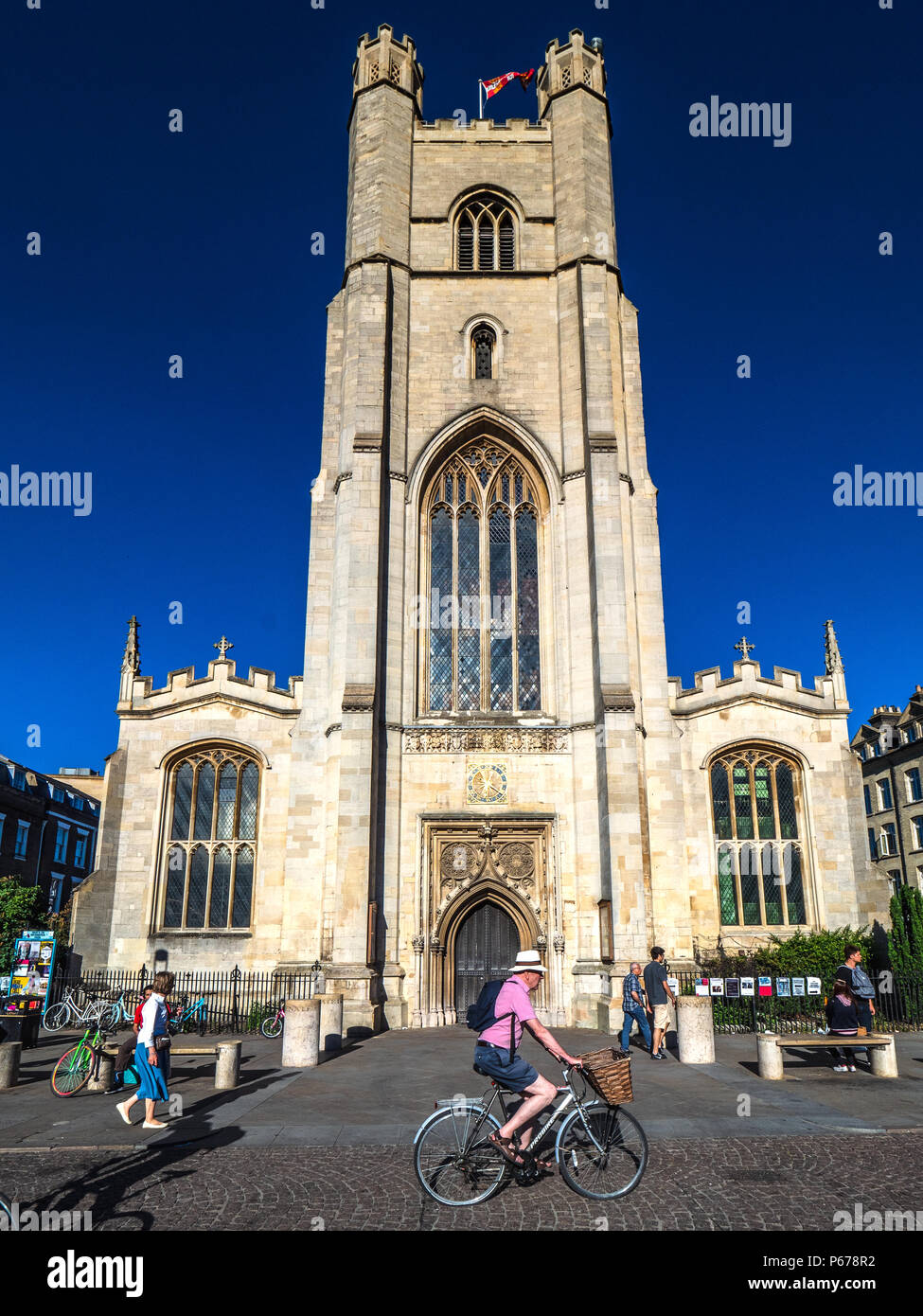 Cambridge Tourism - cyclists pass Great St Mary's church in central Cambridge. The church, rebuilt after a fire in 1290, is Cambridge University Churc Stock Photo